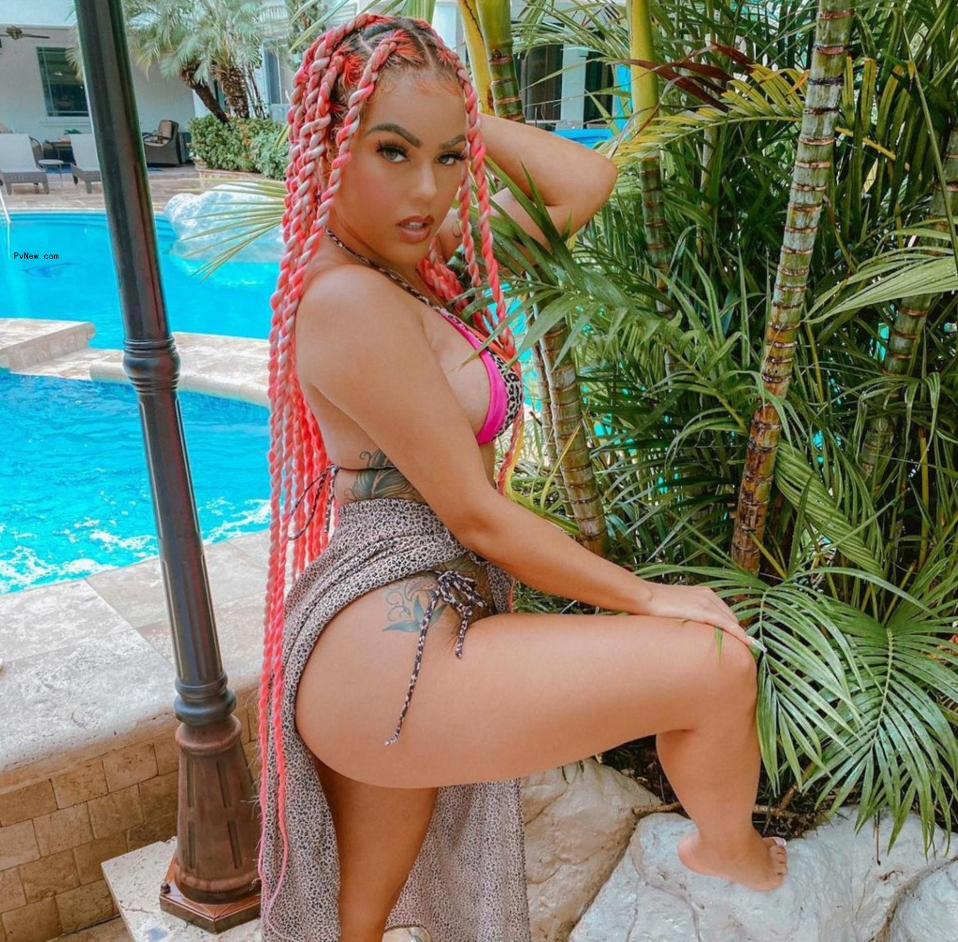 jacky oh posing in a bikini with her leg lifted o<i></i>nto a rock