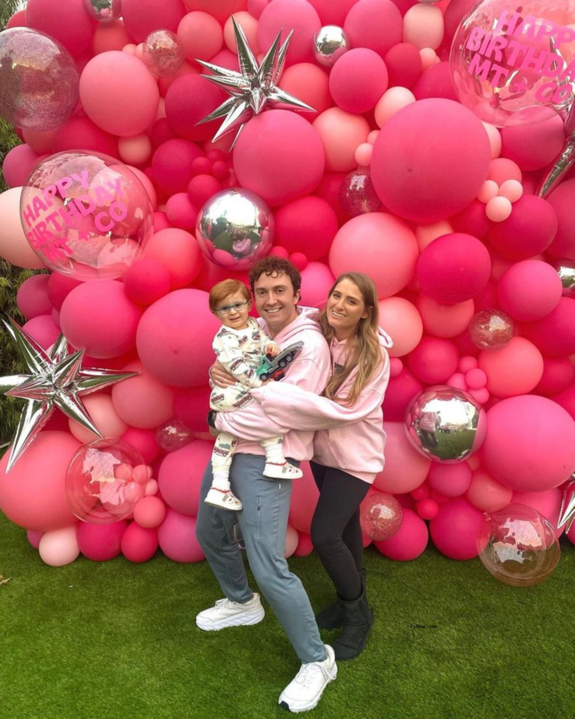 Meghan Trainor, Daryl Sabara and their son Riley in front of a balloon display.