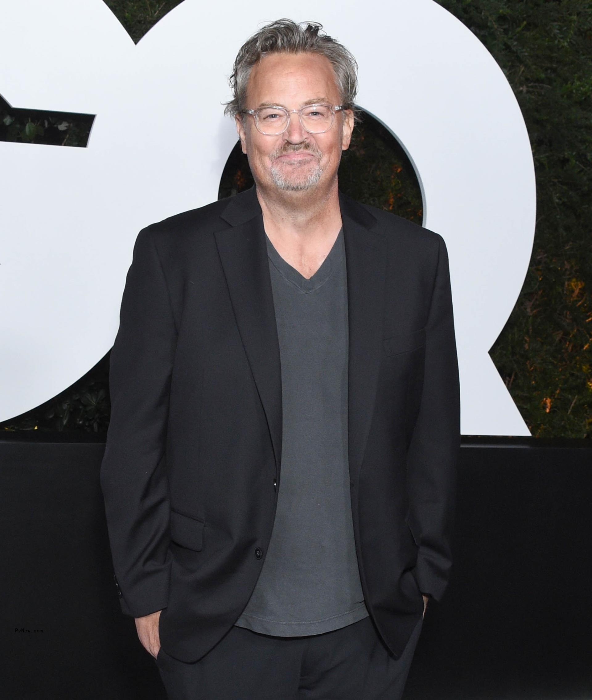 Matthew Perry smiles in suit
