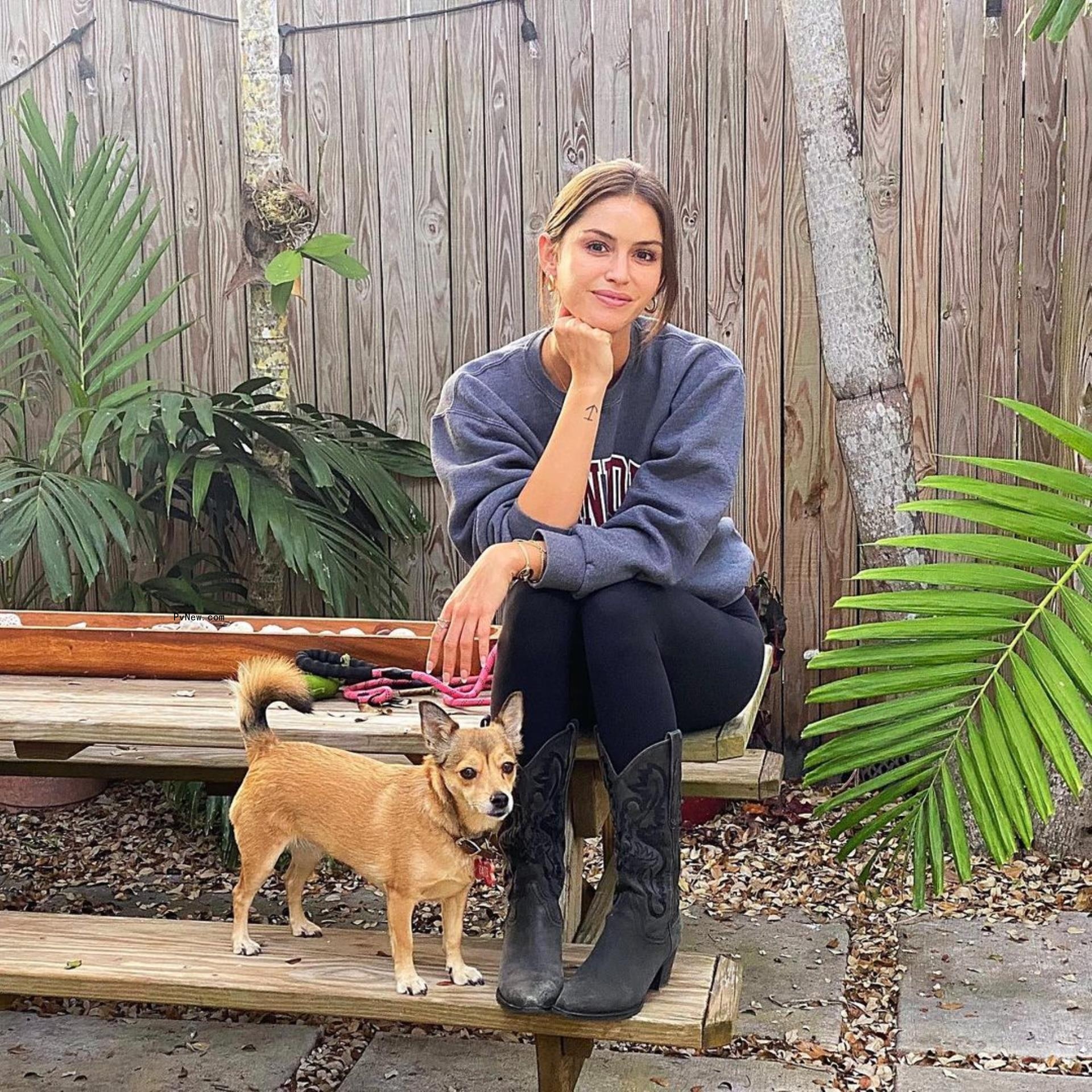 gigi paris sitting on a picnic bench with a dog