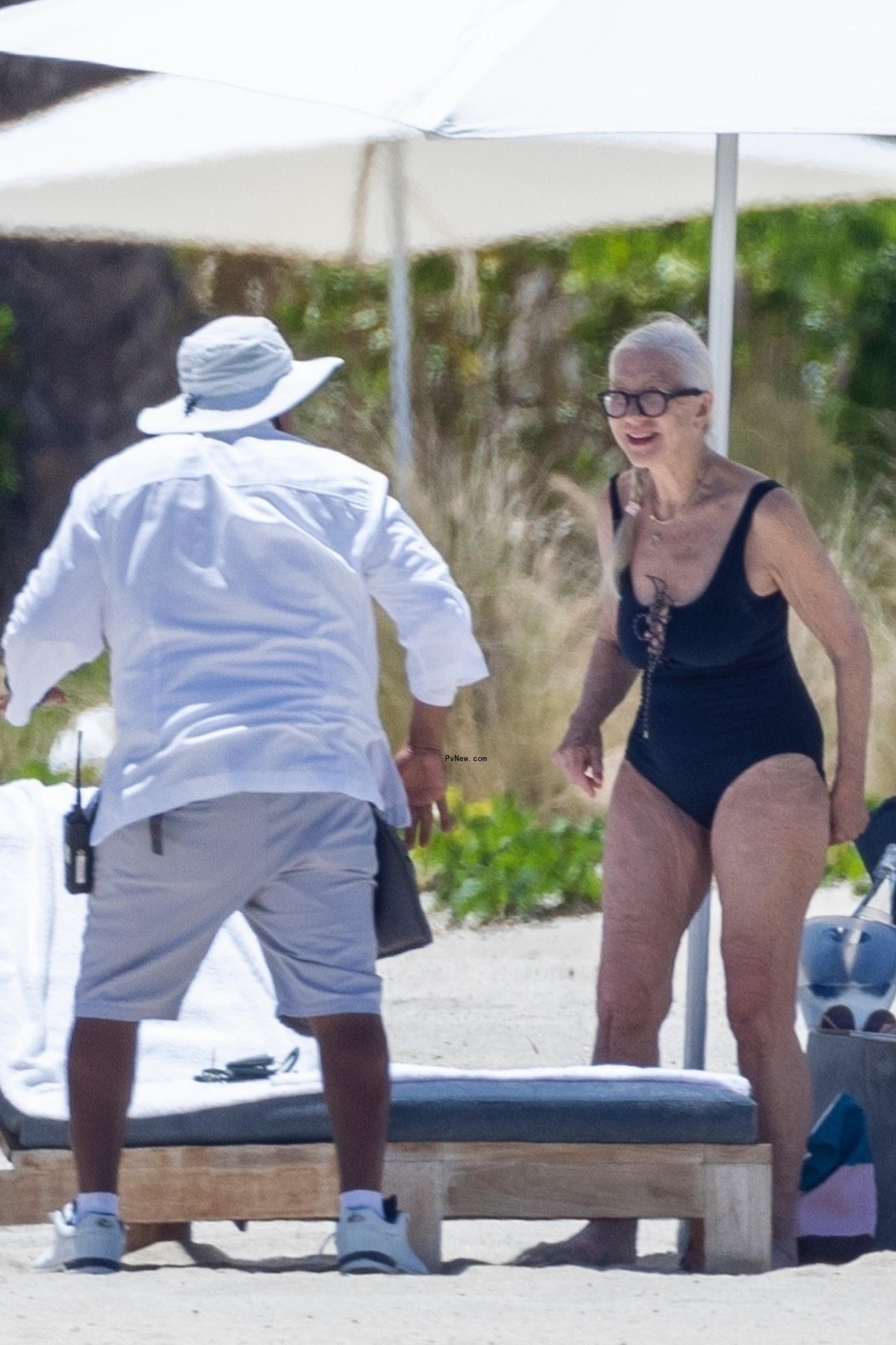 Helen Mirren speaking to a beach attendant.