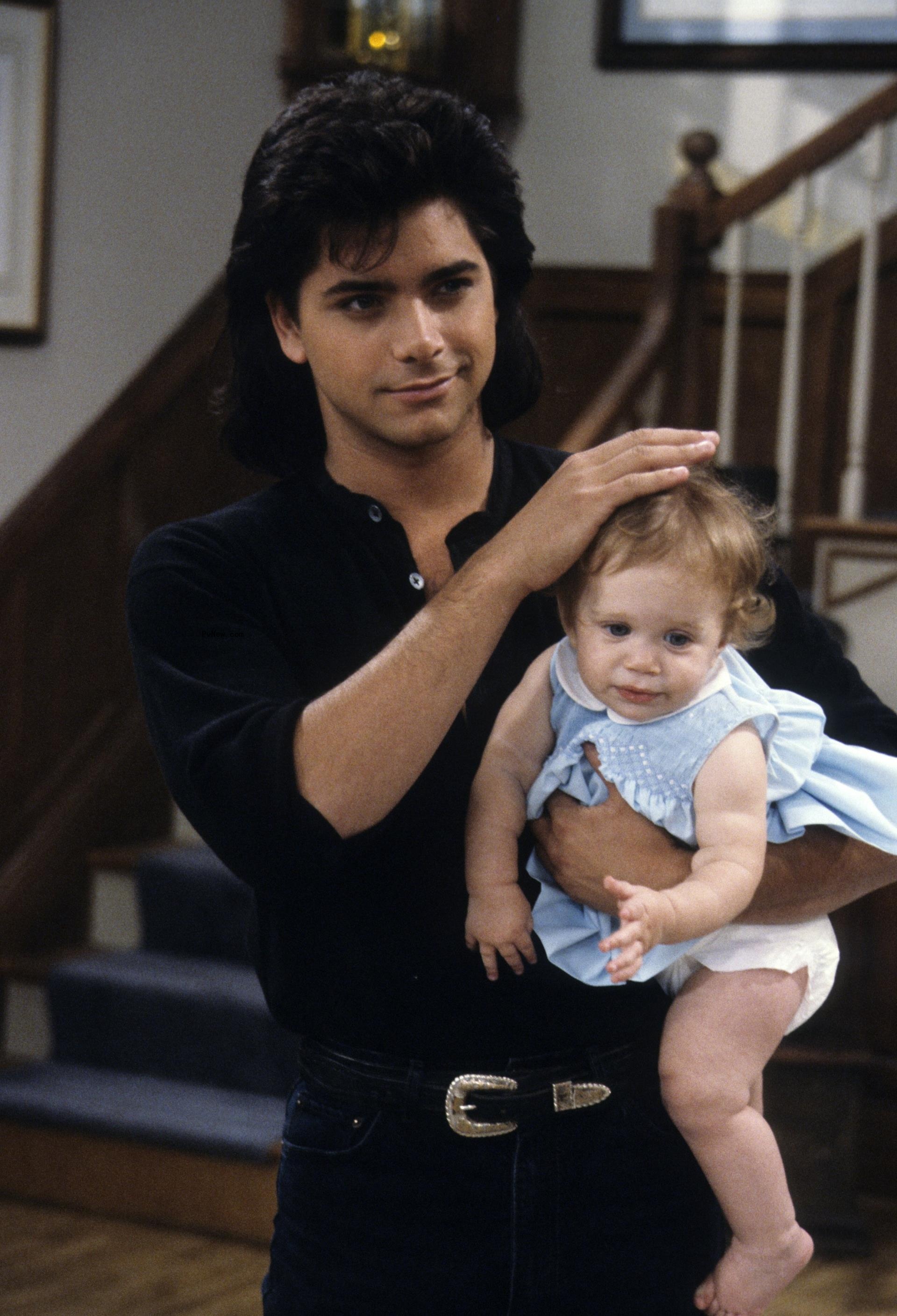 John Stamos holding one of the Olsen twins for 