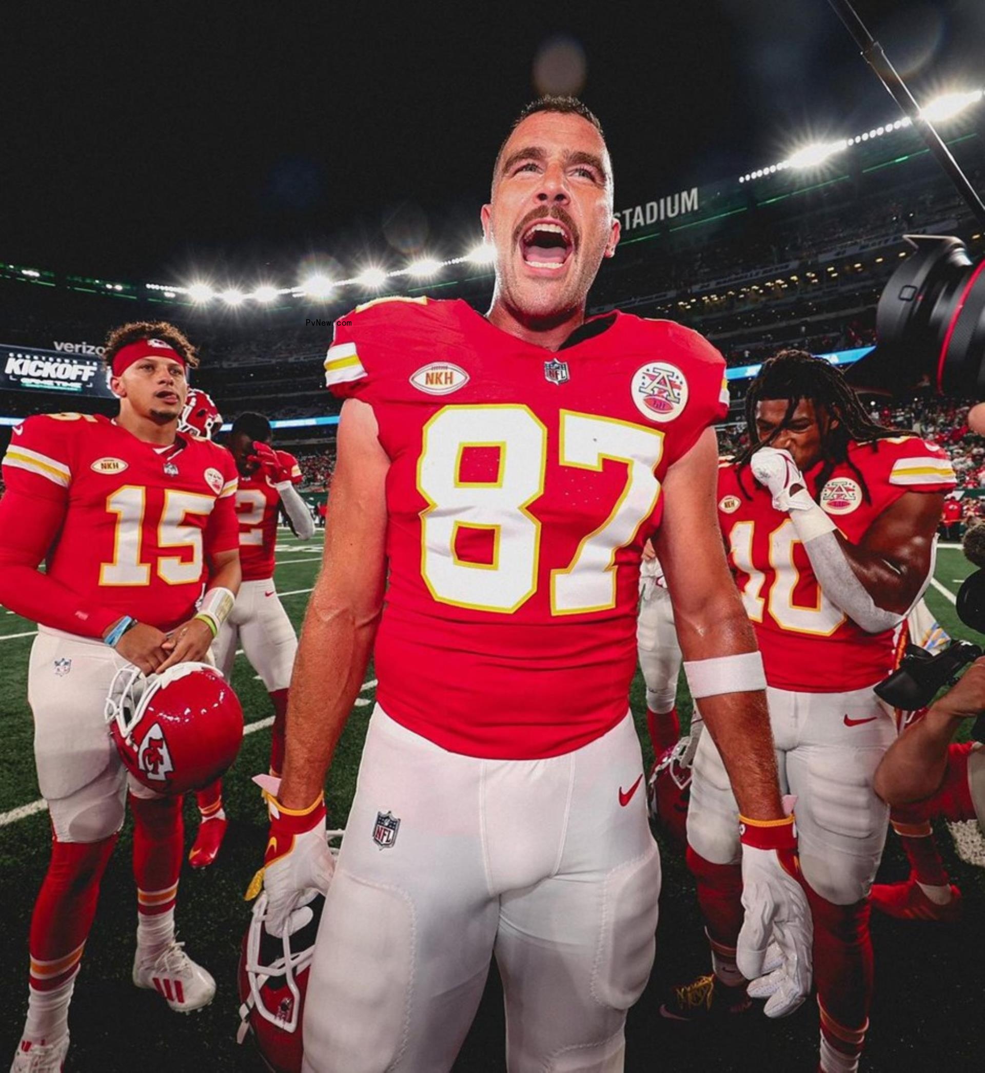 Travis Kelce cheering in his Chiefs uniform on the field