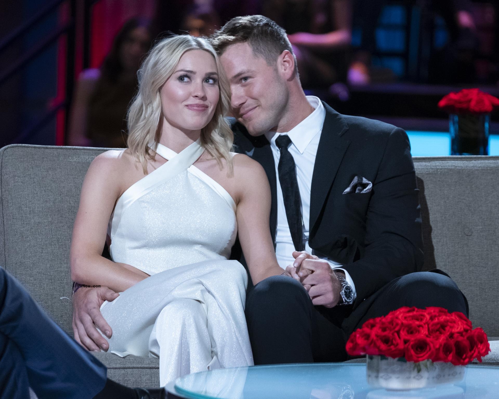 Colton Underwood and Cassie Randolph hold hands on couch
