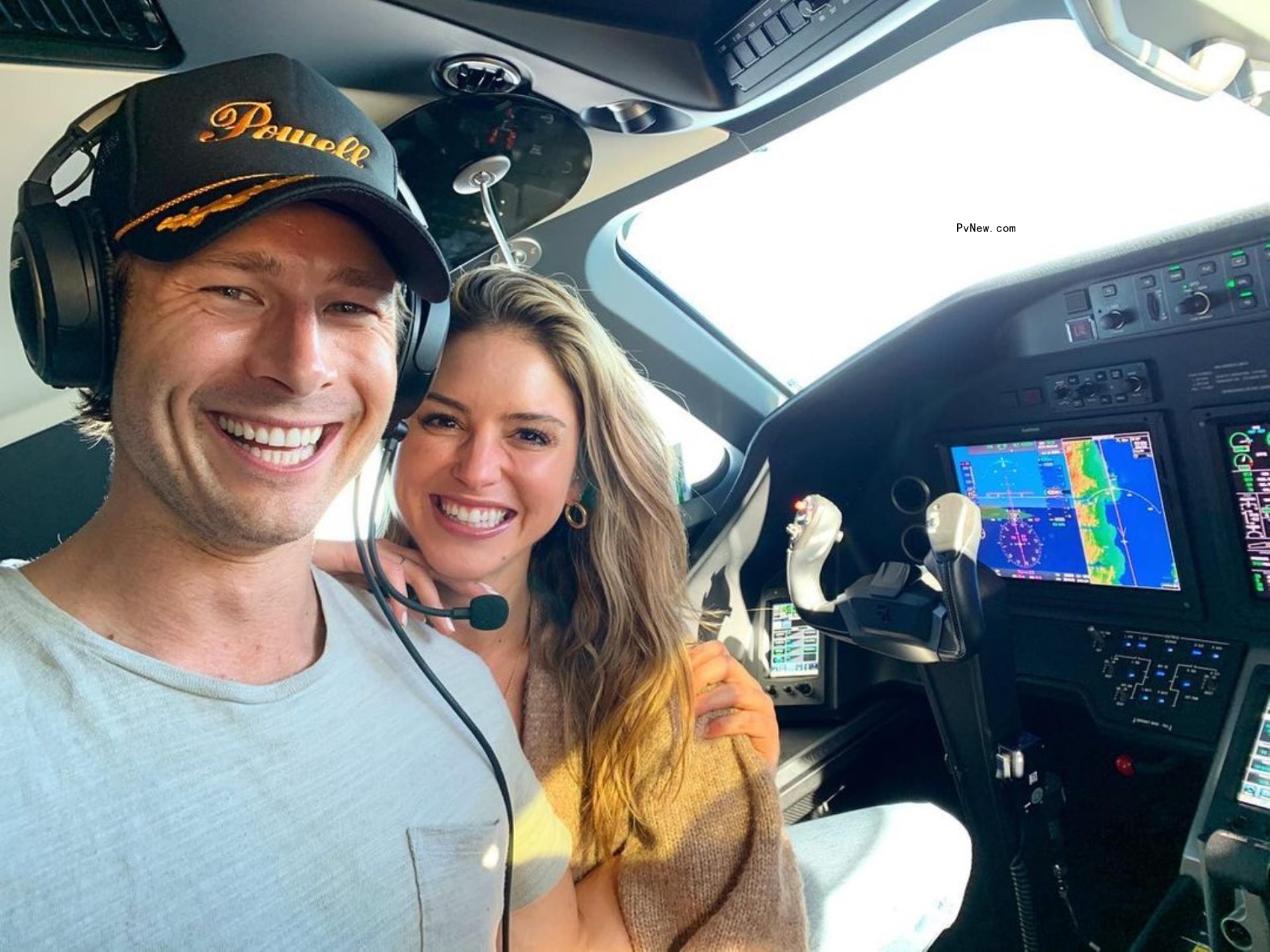 Glen Powell and Gigi Paris posing in a helicopter