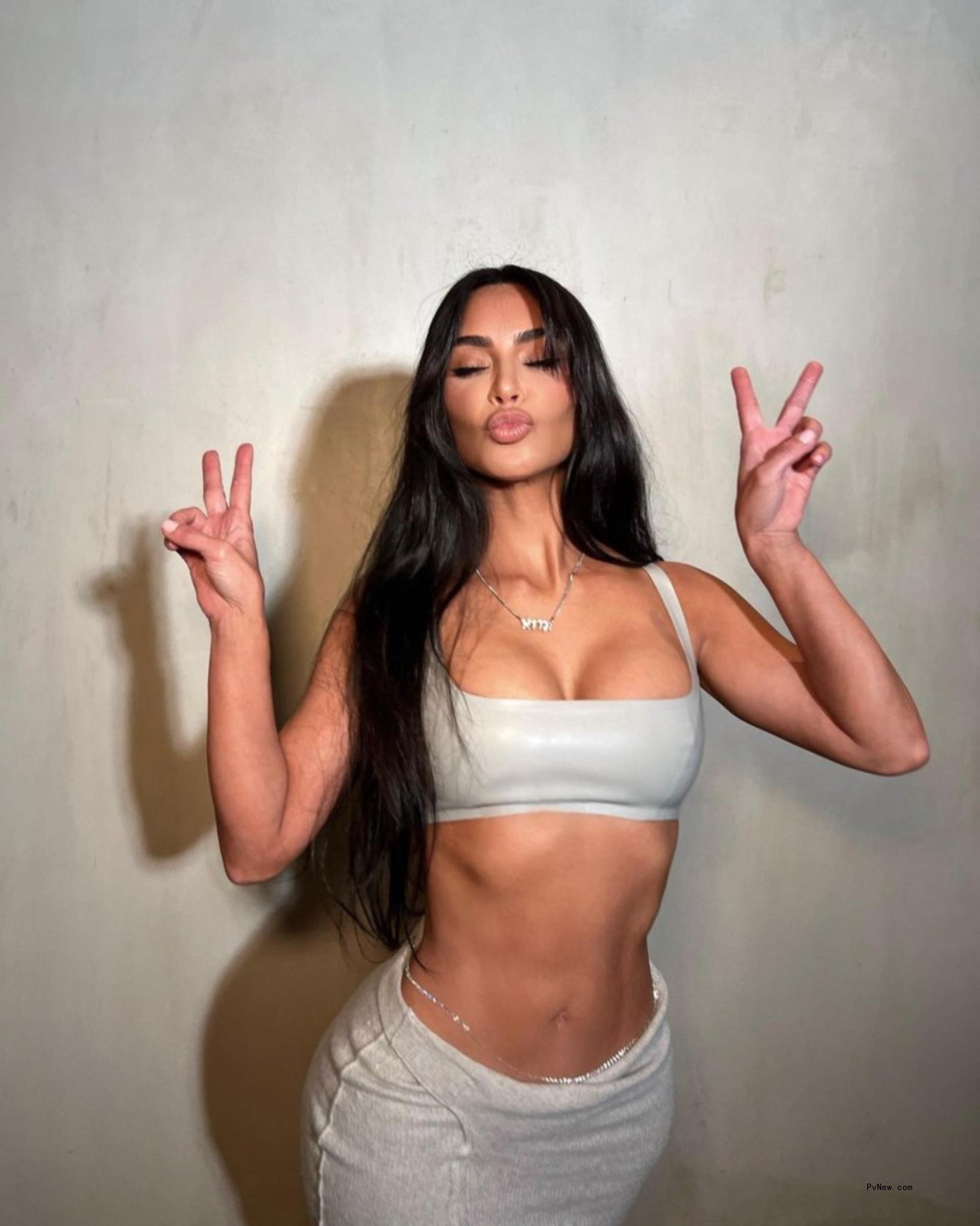 Kim Kardashian throwing up peace signs. 