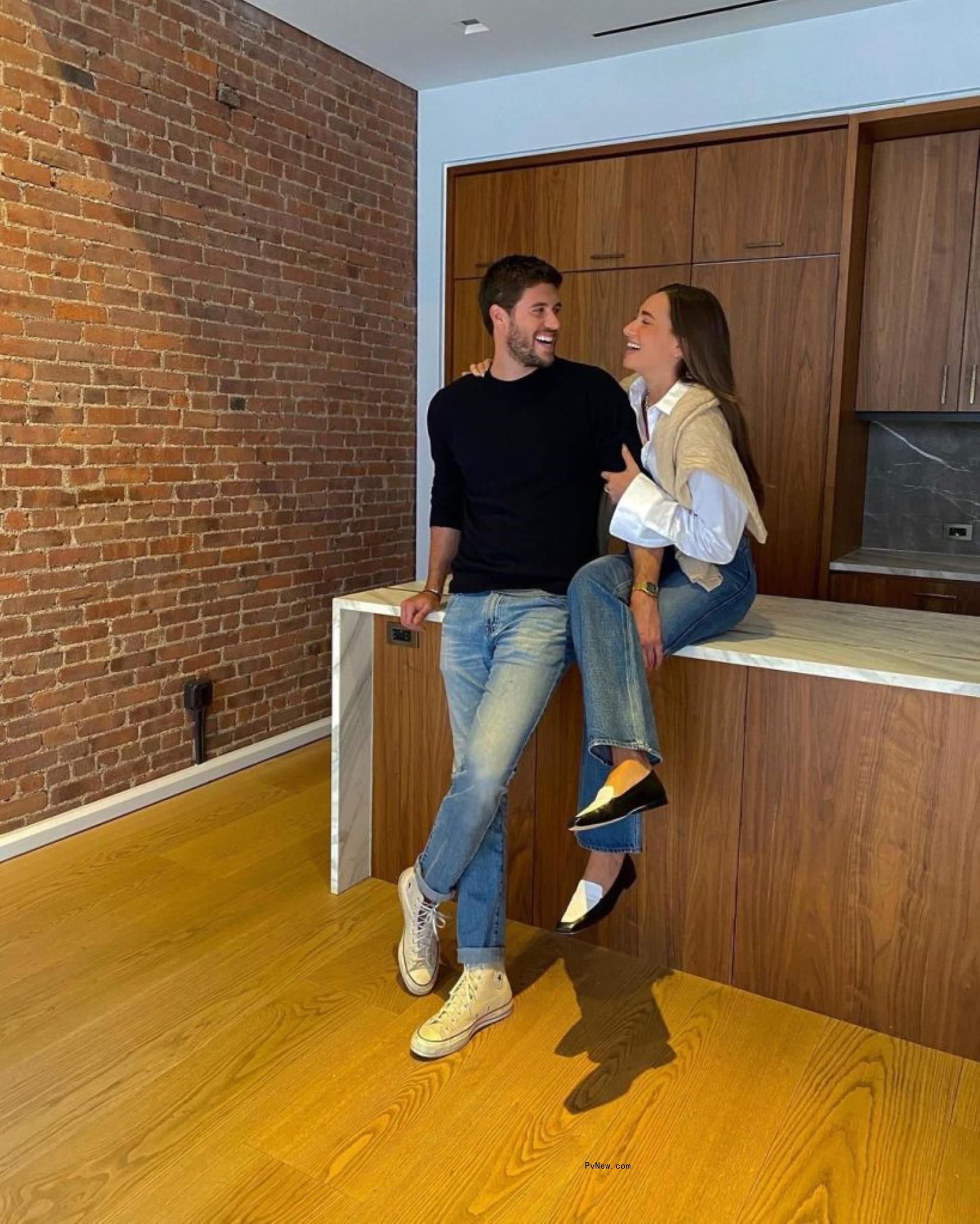Danielle Bernstein and Anthony Adler sitting on a kitchen island.