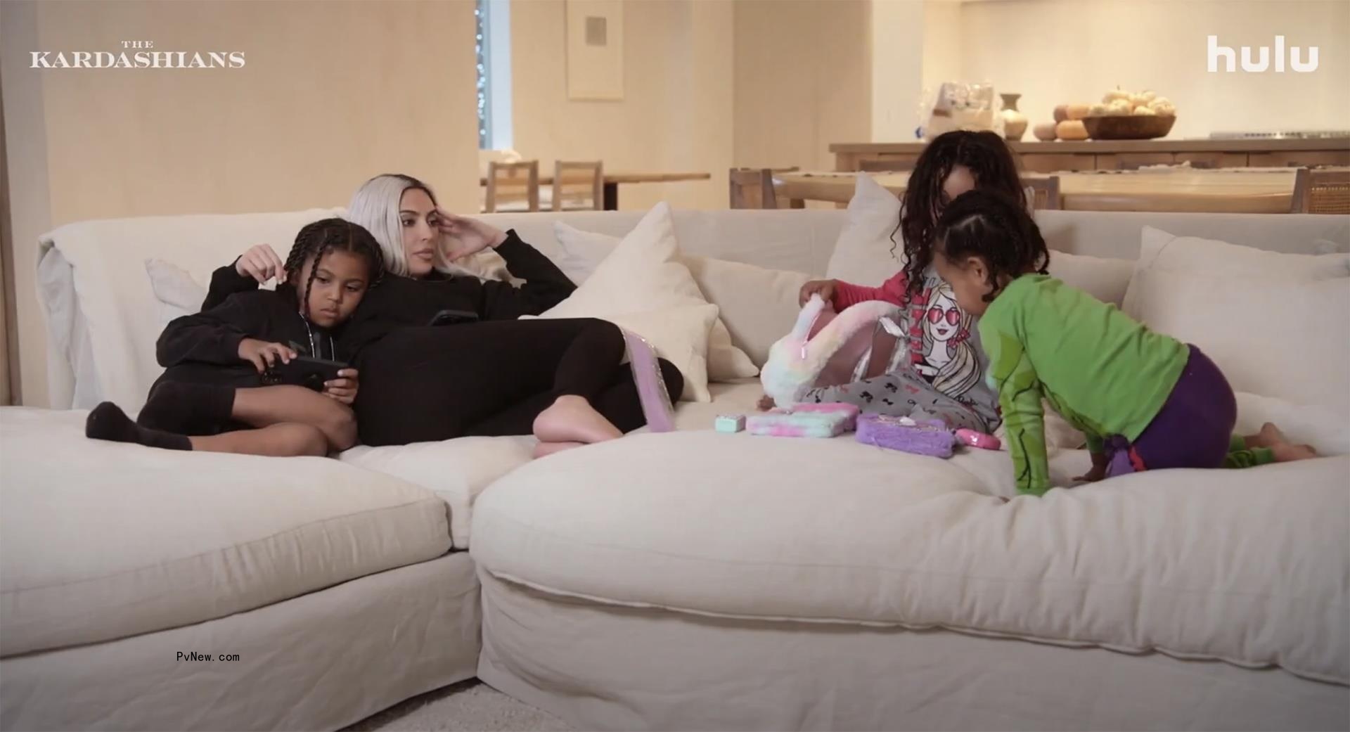 Kim Kardashian sitting on a couch with her kids
