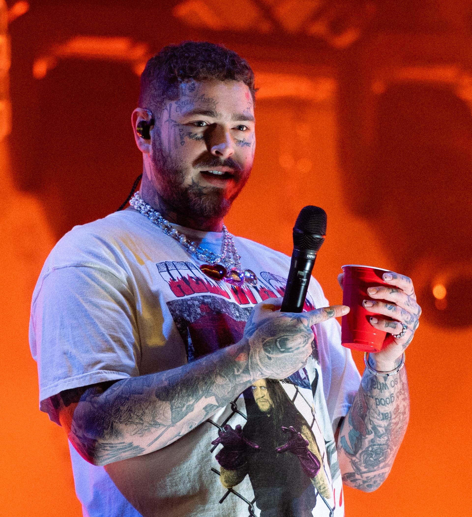 Post Malone holding a mic and a red solo cup while onstage.