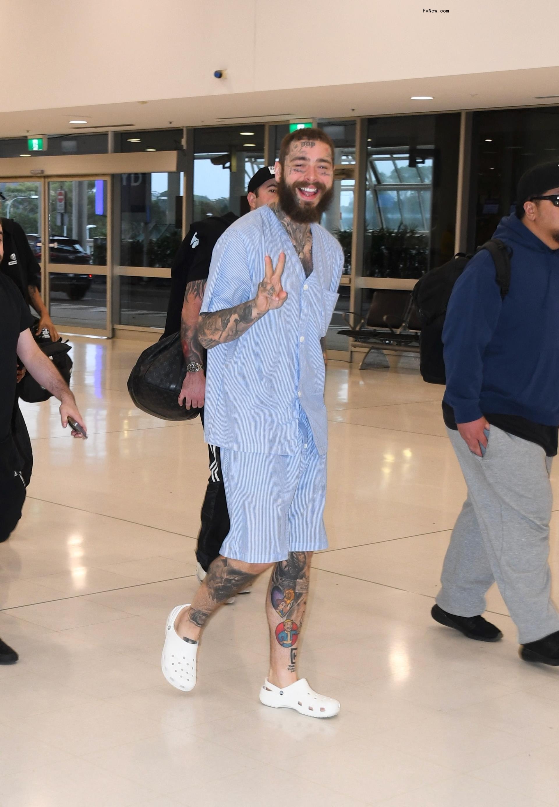 Post Malone waving while at the airport.