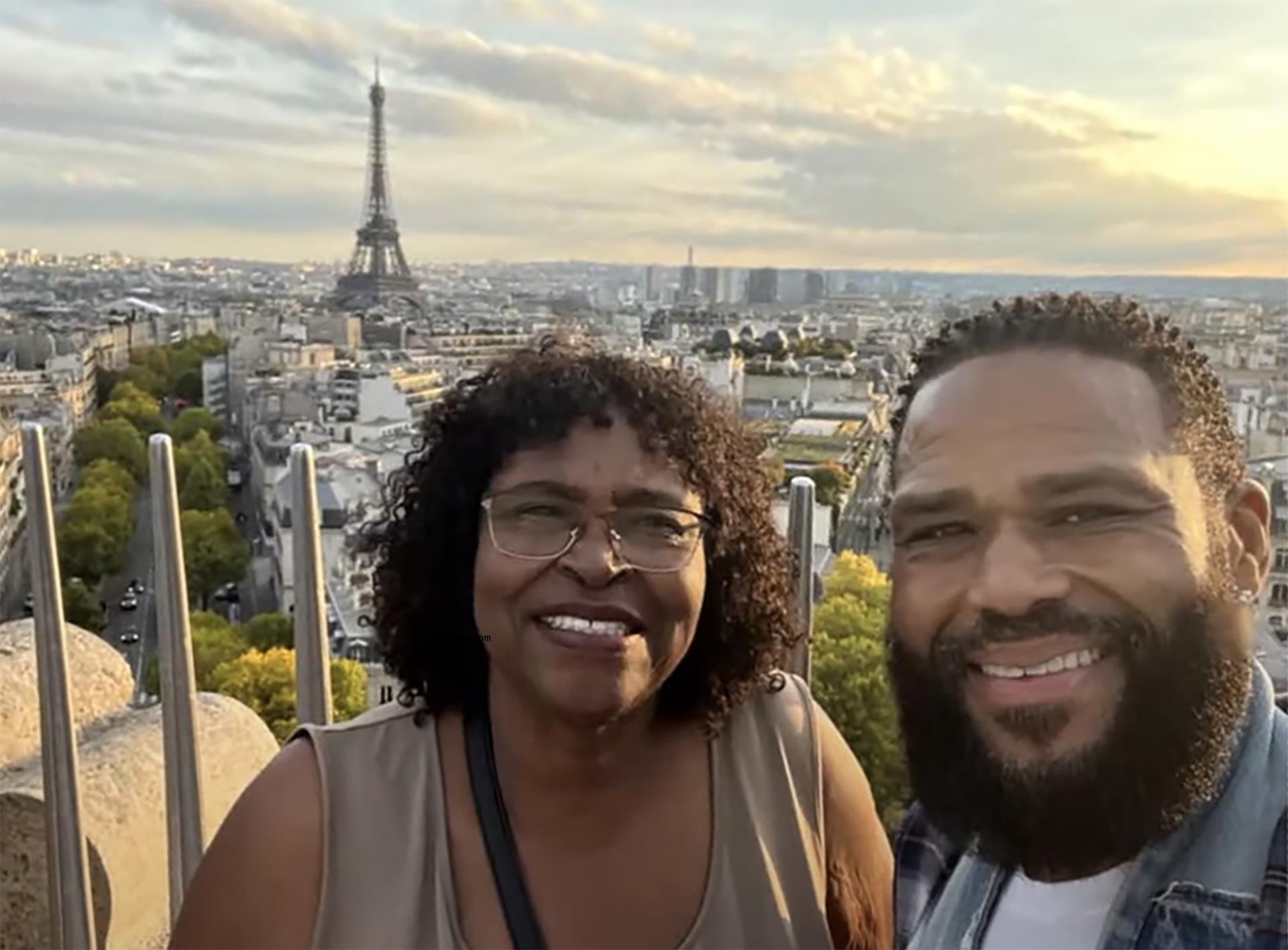 Anthony Anderson and hjs mother posing for a selfie with the Eiffel Tower in the background
