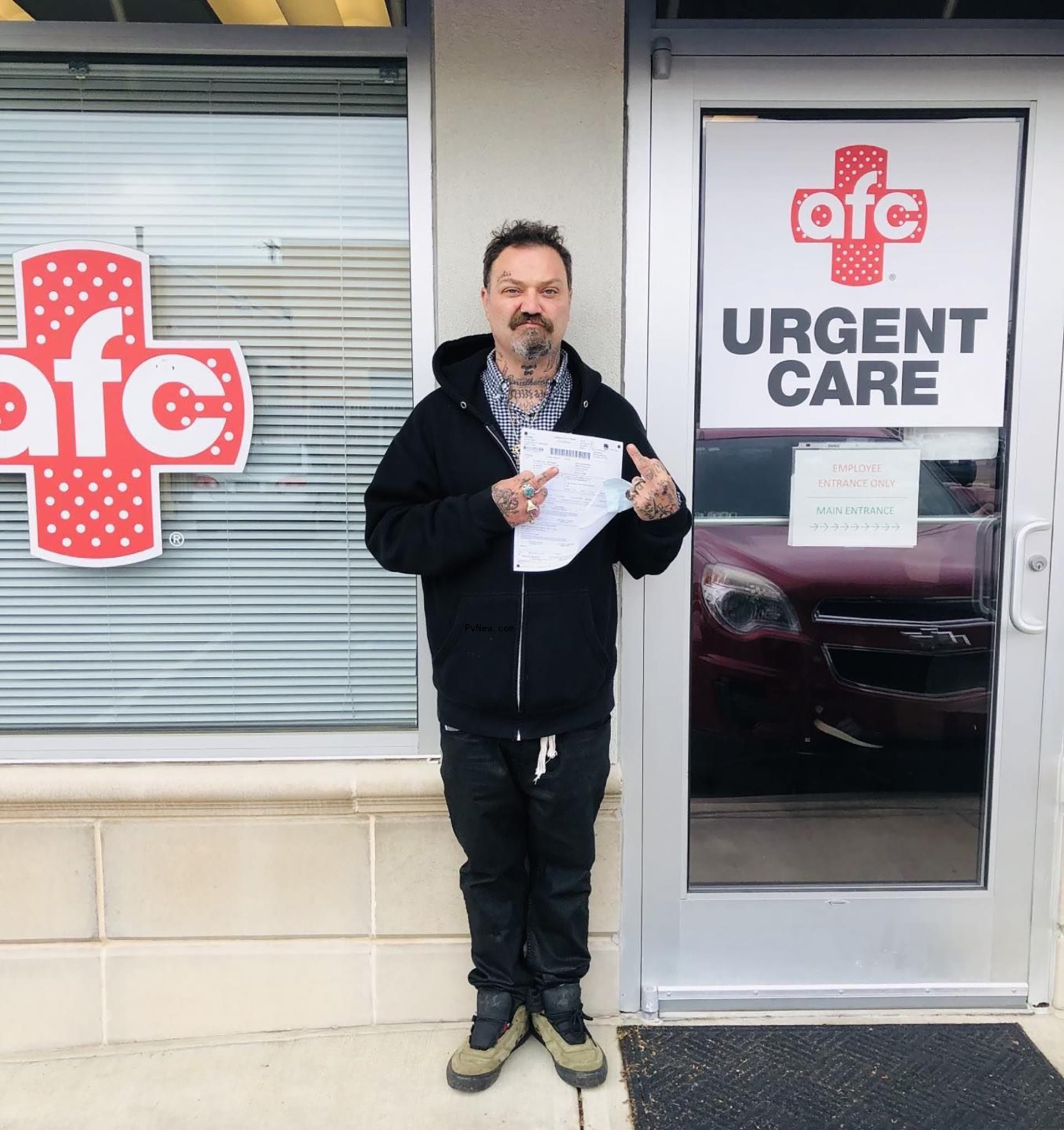 Bam Margera holding piece of paper outside of urgent care facility