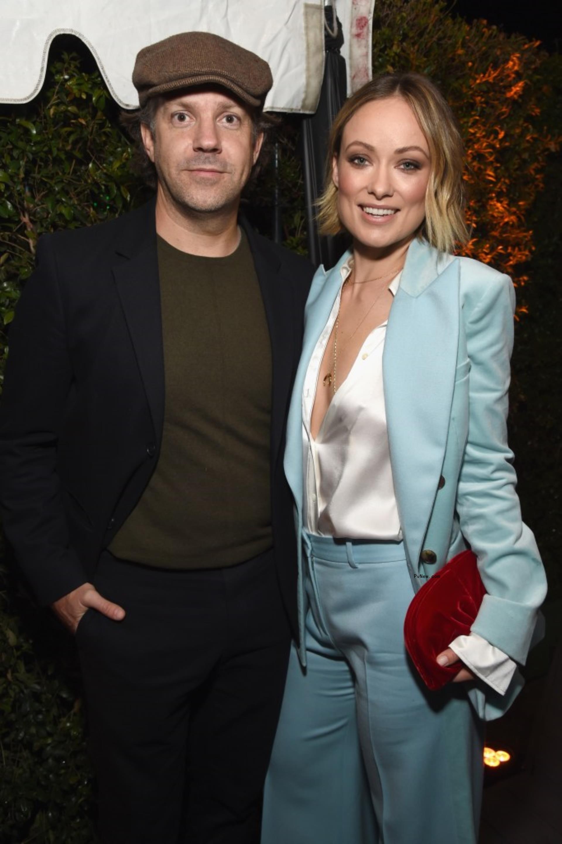 Jason Sudeikis and Olivia Wilde smile at a formal event 