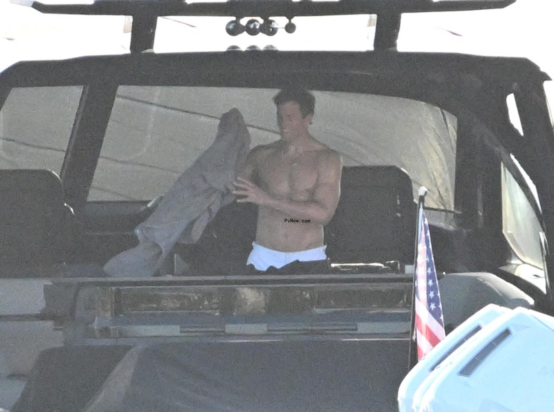 shirtless tom brady handling a shirt on his yacht