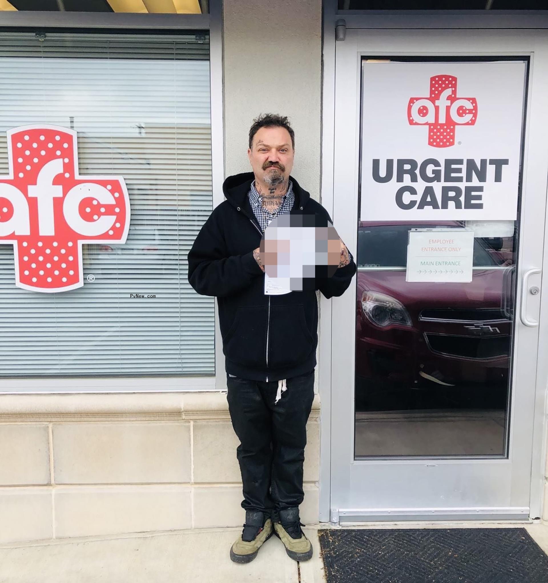 bam margera holding a paper in front of an urgent care