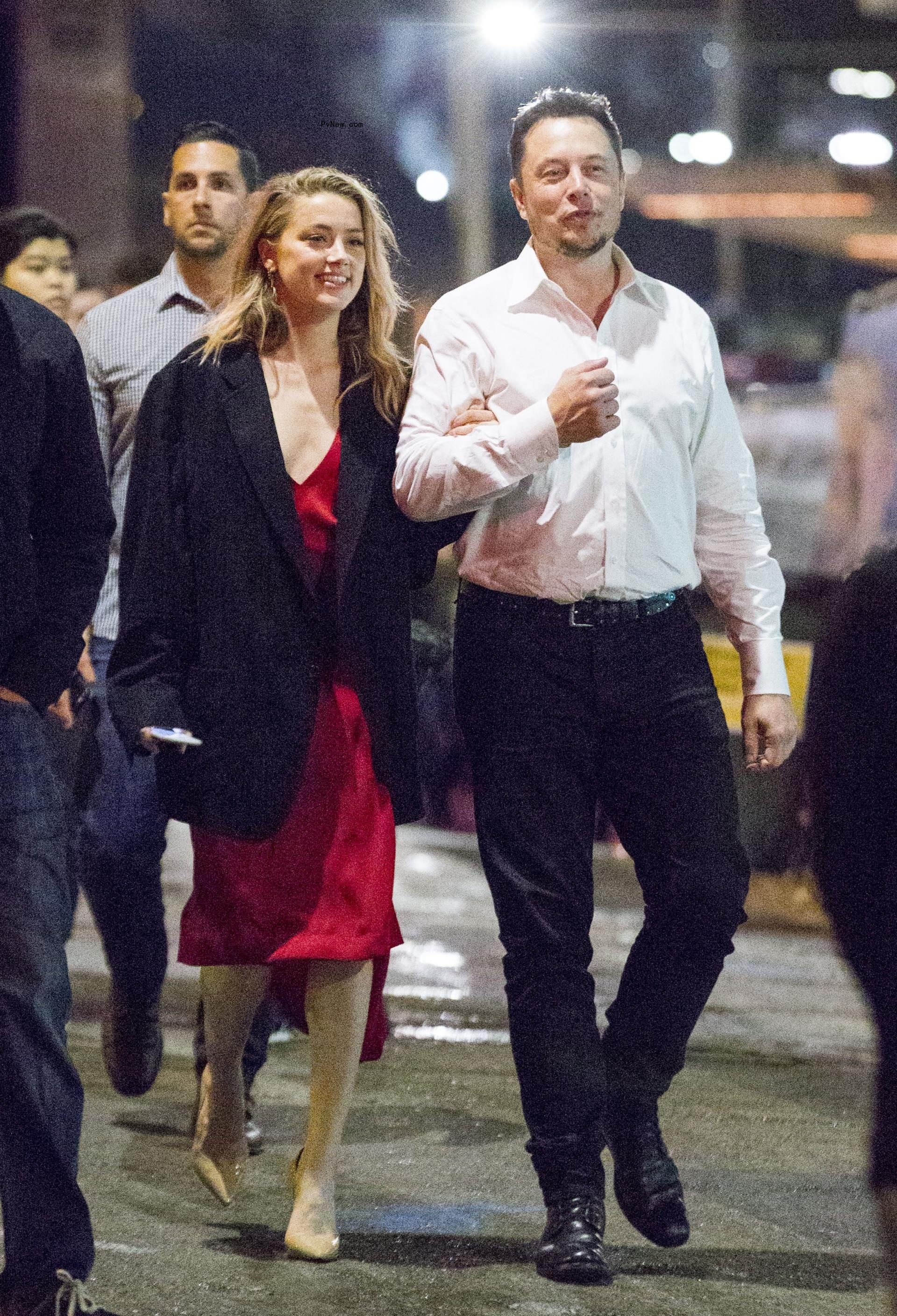 Amber Heard and Elon Musk walking together.