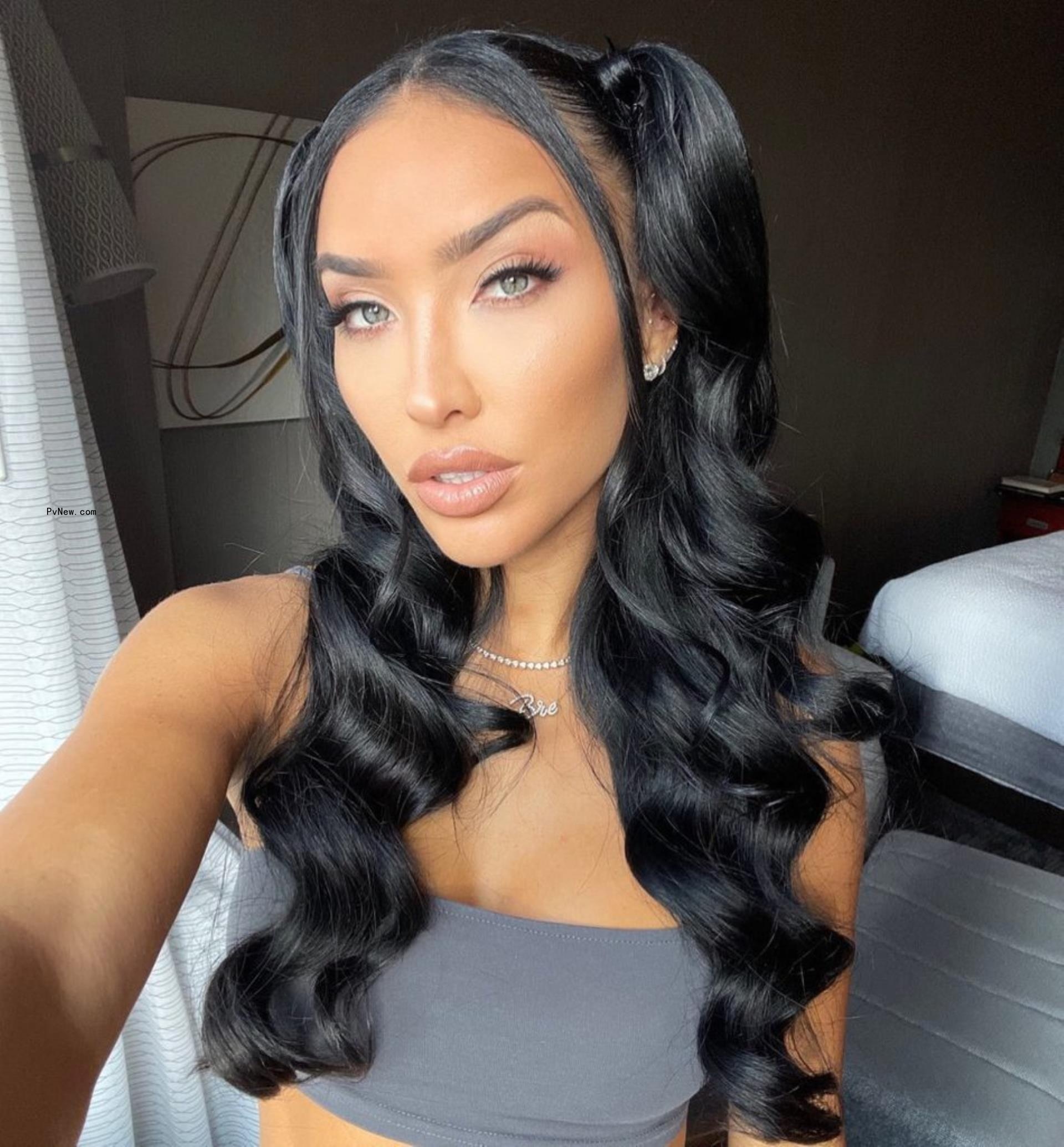 Bre Tiesi poses for a selfie in a gray sports bra