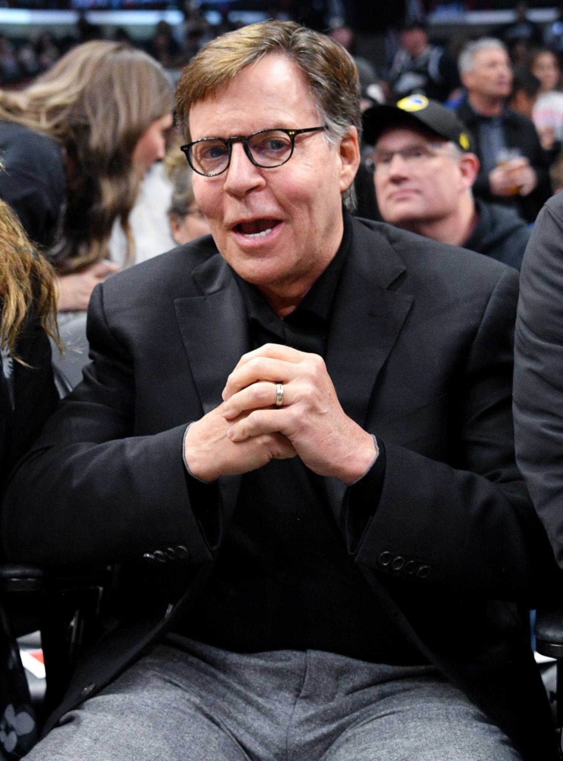 bob costas talking into a microphone on the sidelines of a football game