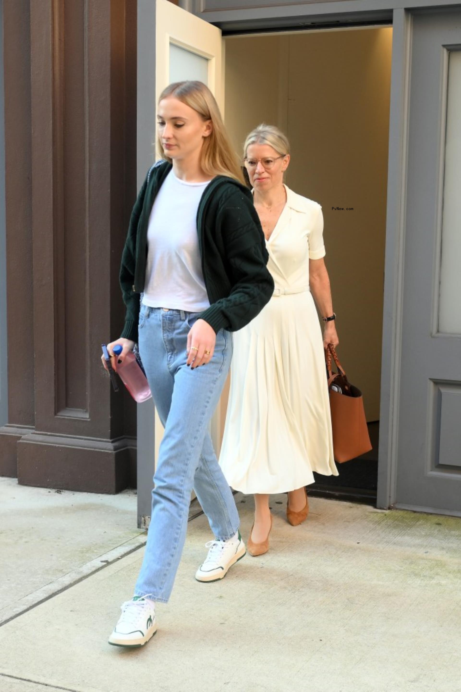 sophie turner exiting a building with her lawyer behind her