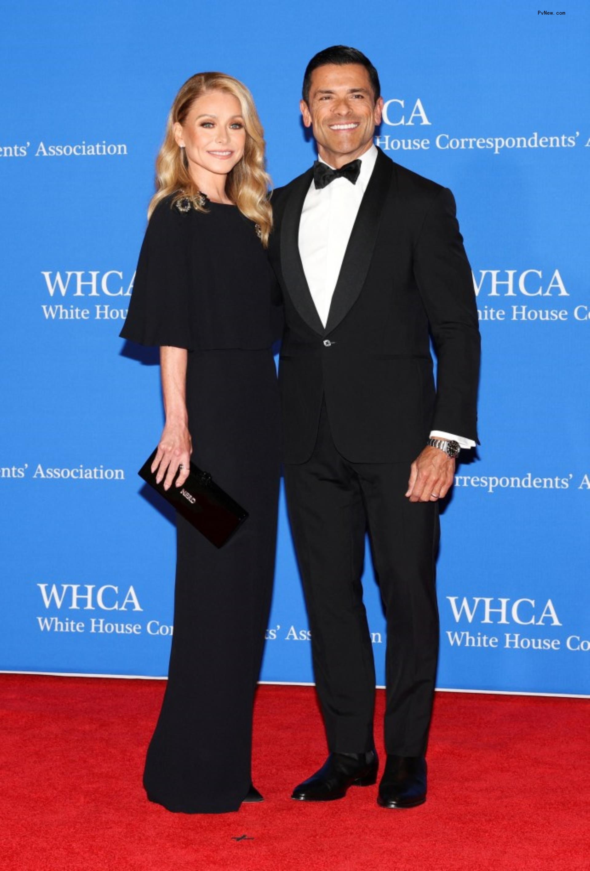 Kelly Ripa and Mark Co<i></i>nsuelos on a red carpet.