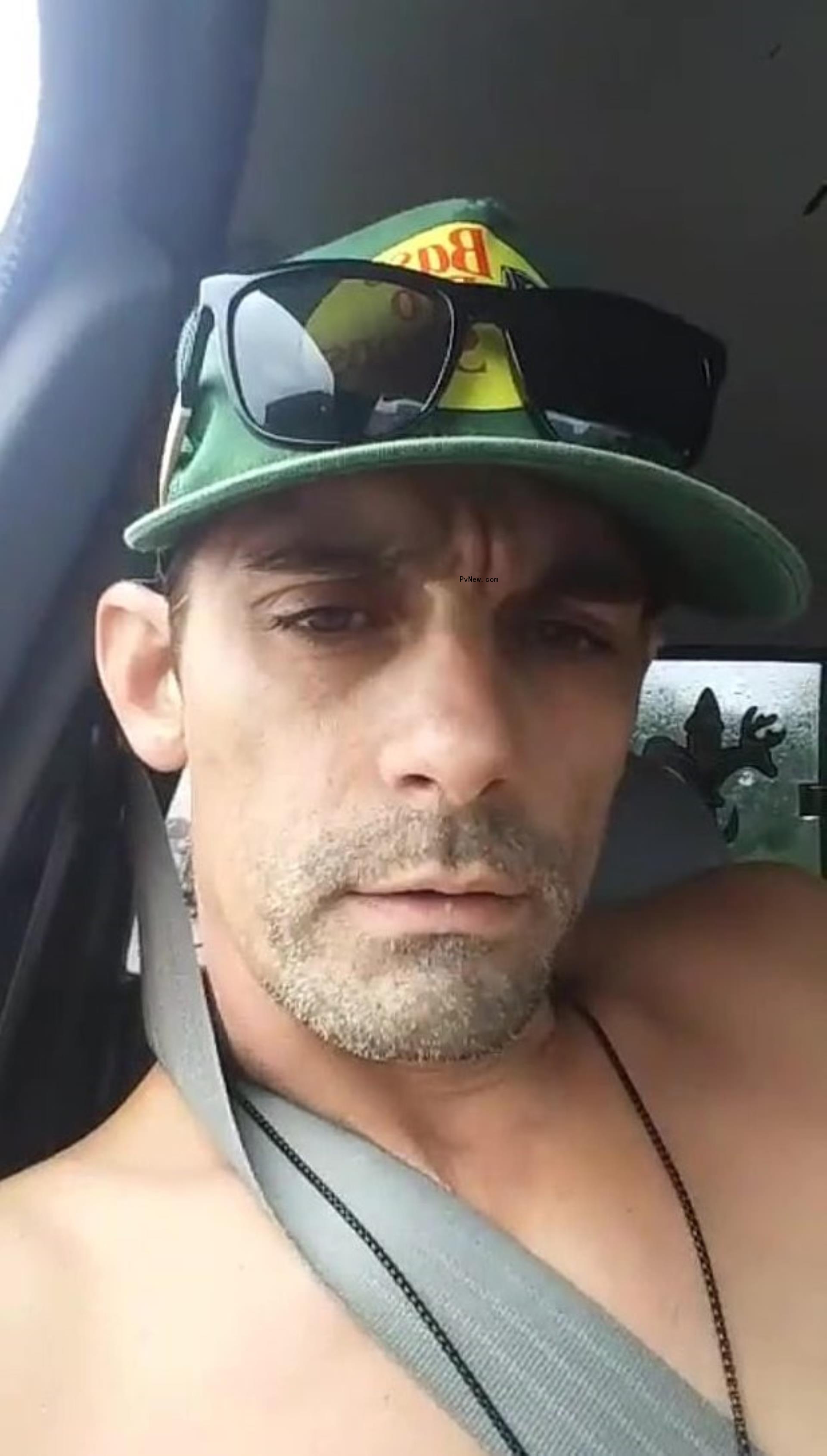 Jason Alexander sitting shirtless in a car.