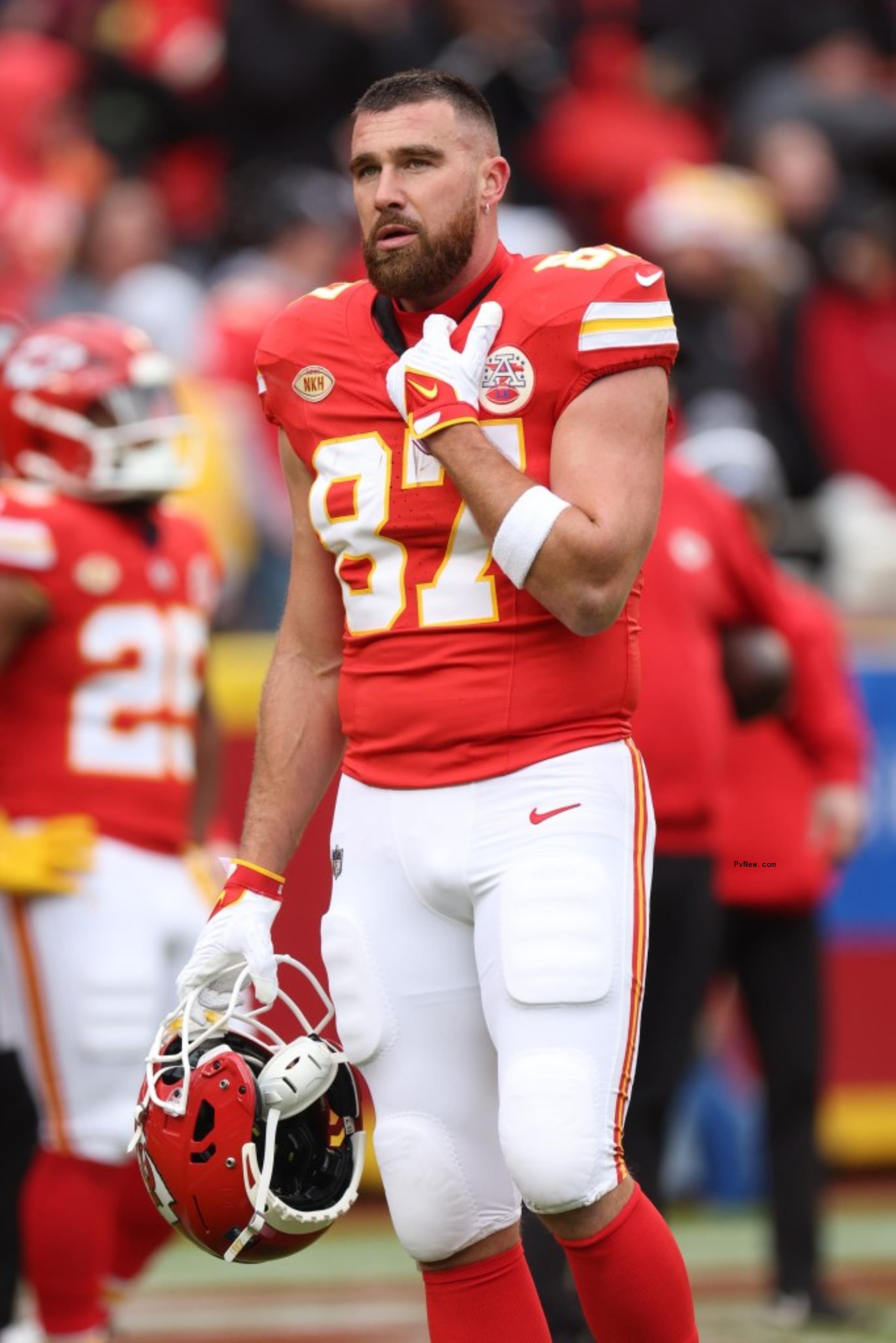 travis kelce on the football field with his helmet off