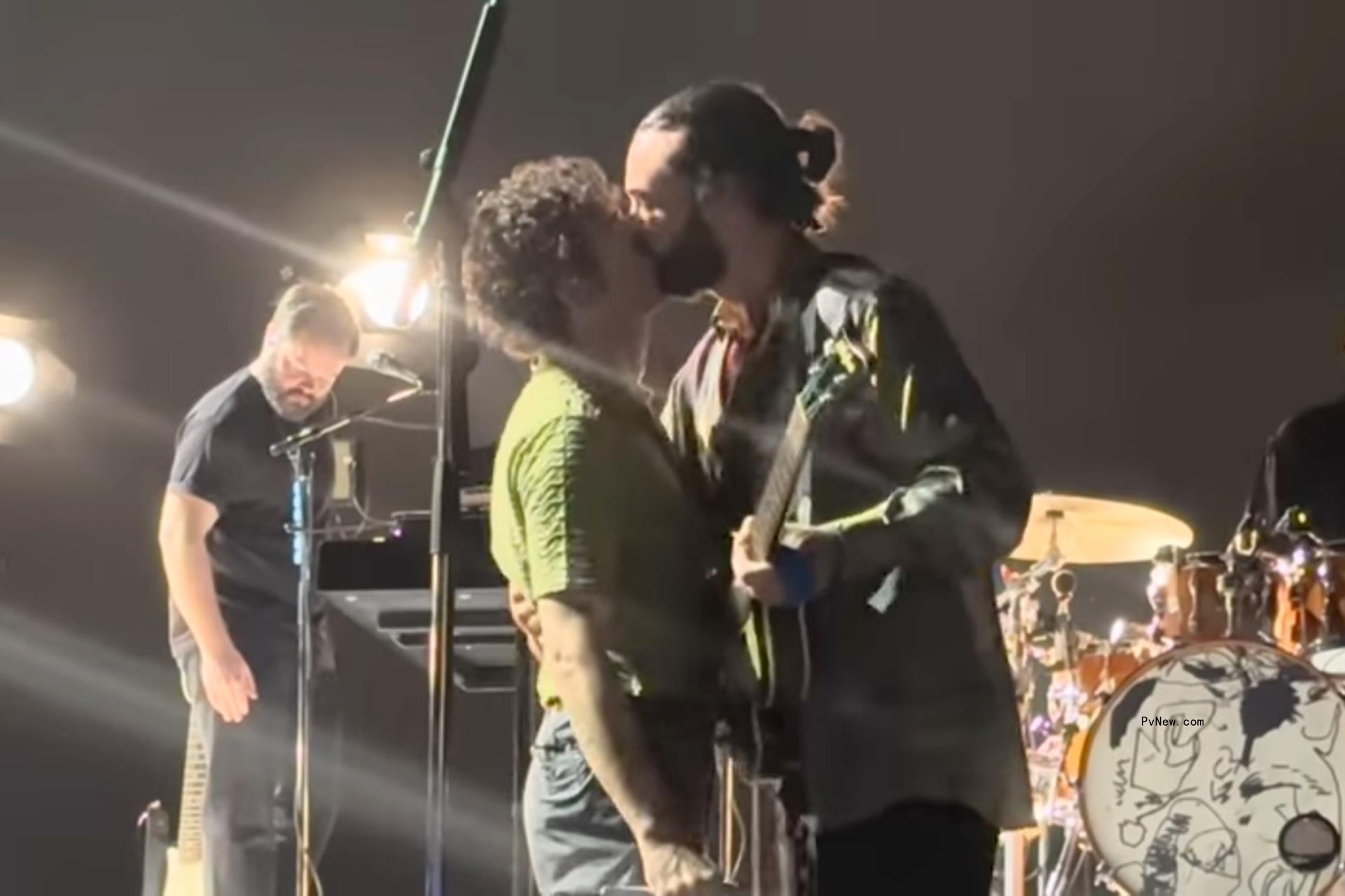 Matty Healy kissing Ross Macdo<i></i>nald onstage.