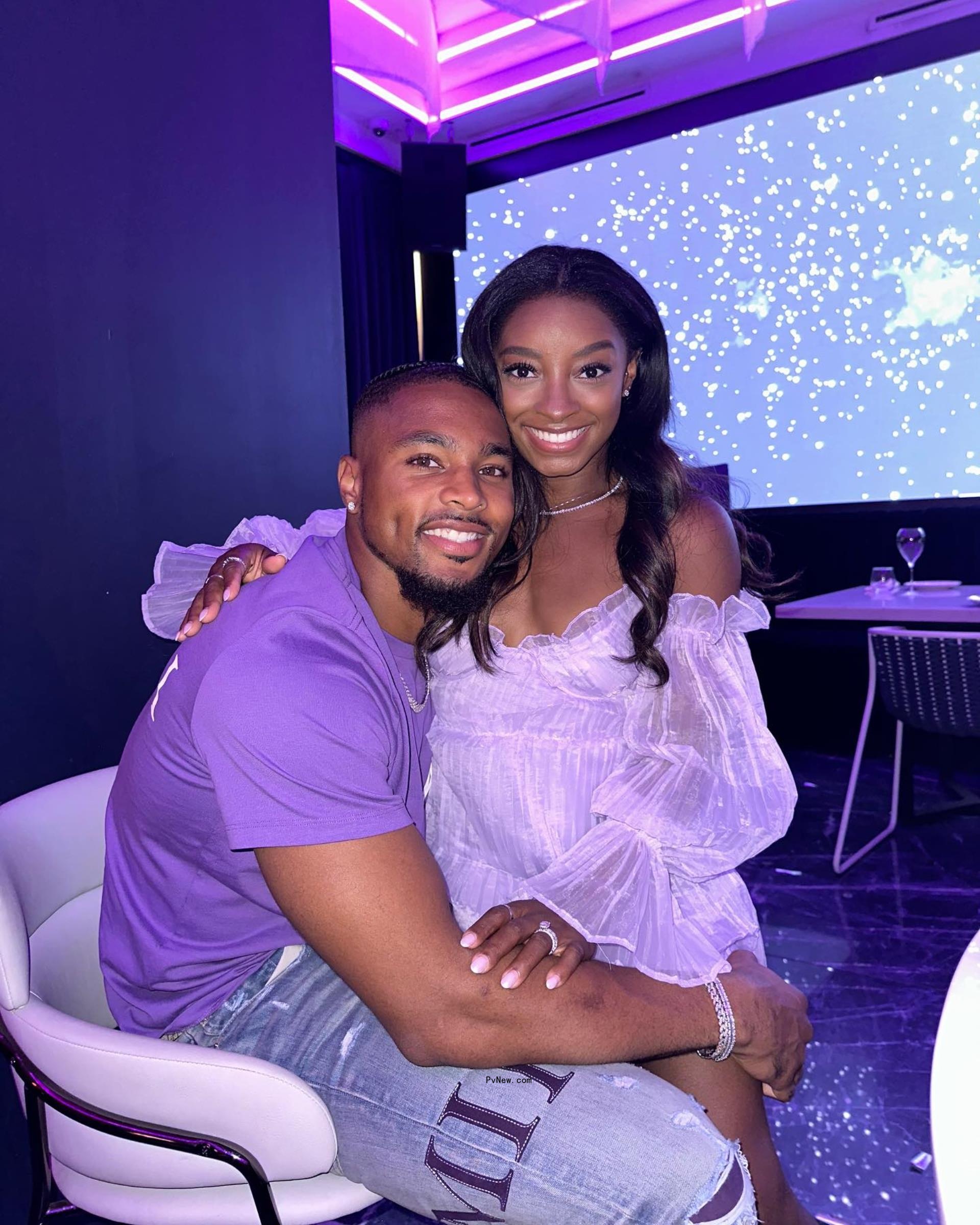 Simone Biles sitting on Jo<i></i>nathan Owens' lap.