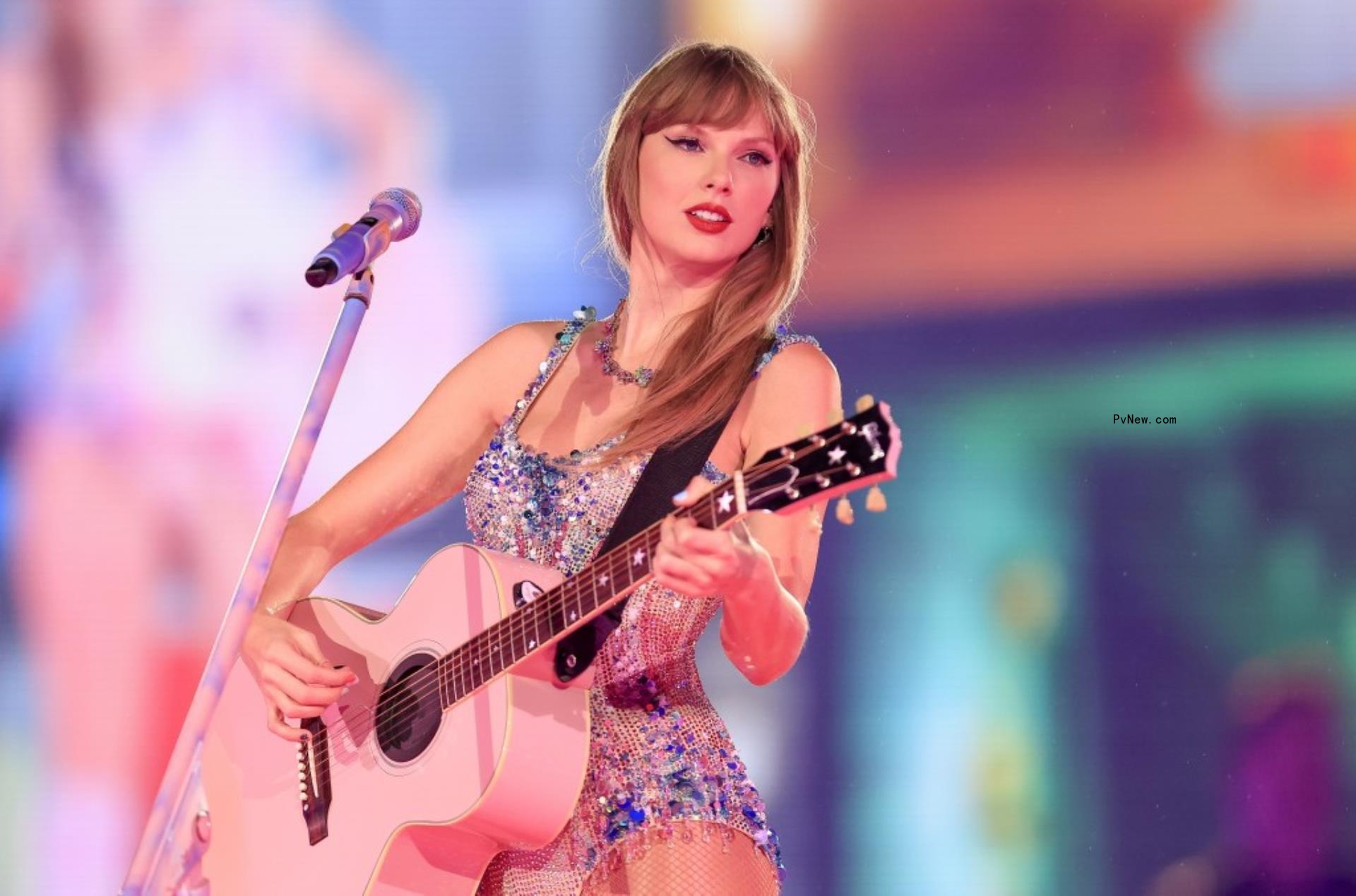 Taylor Swift playing a pink guitar