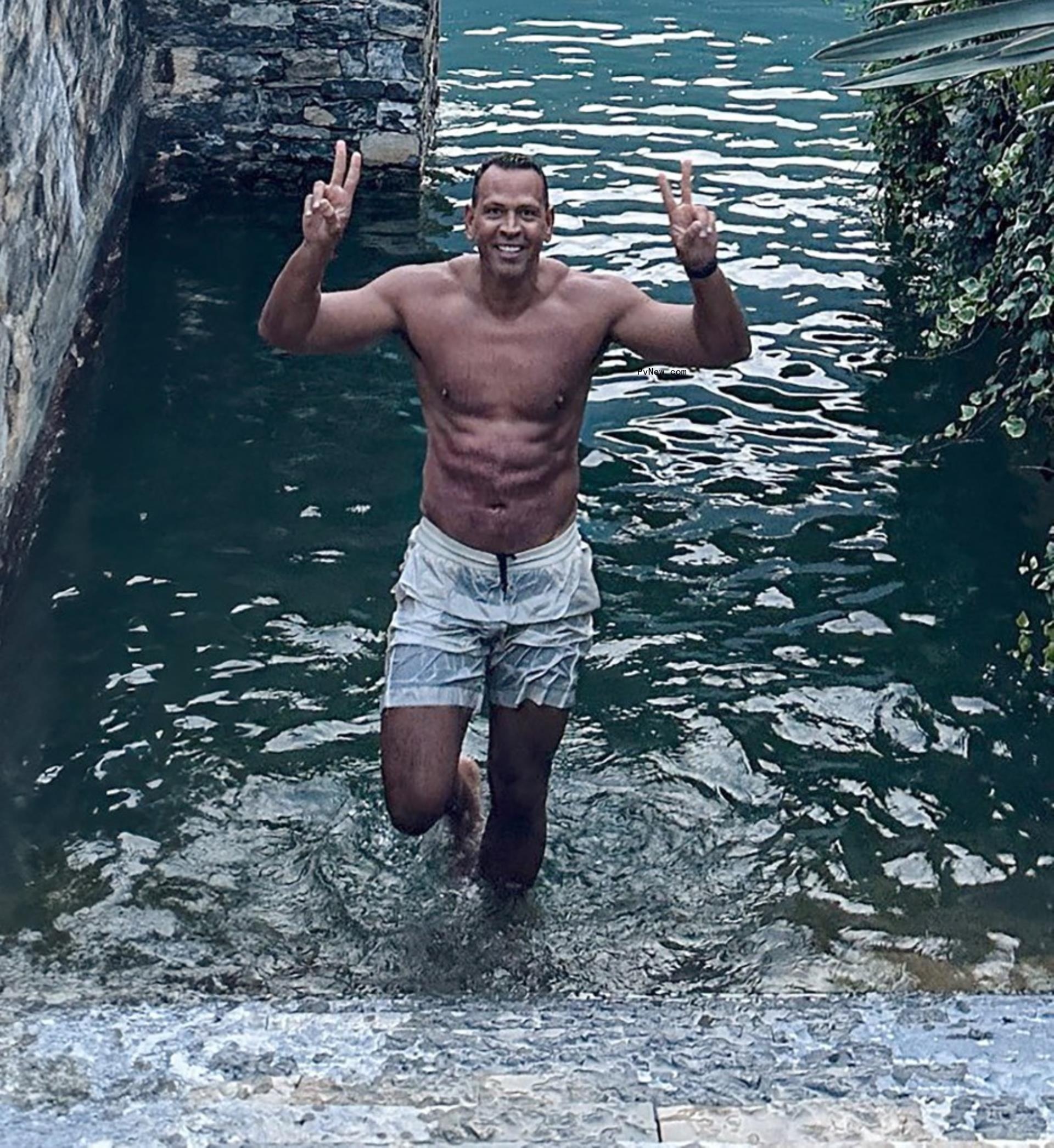 shirtless alex rodriguez getting out of the ocean and holding up peace signs