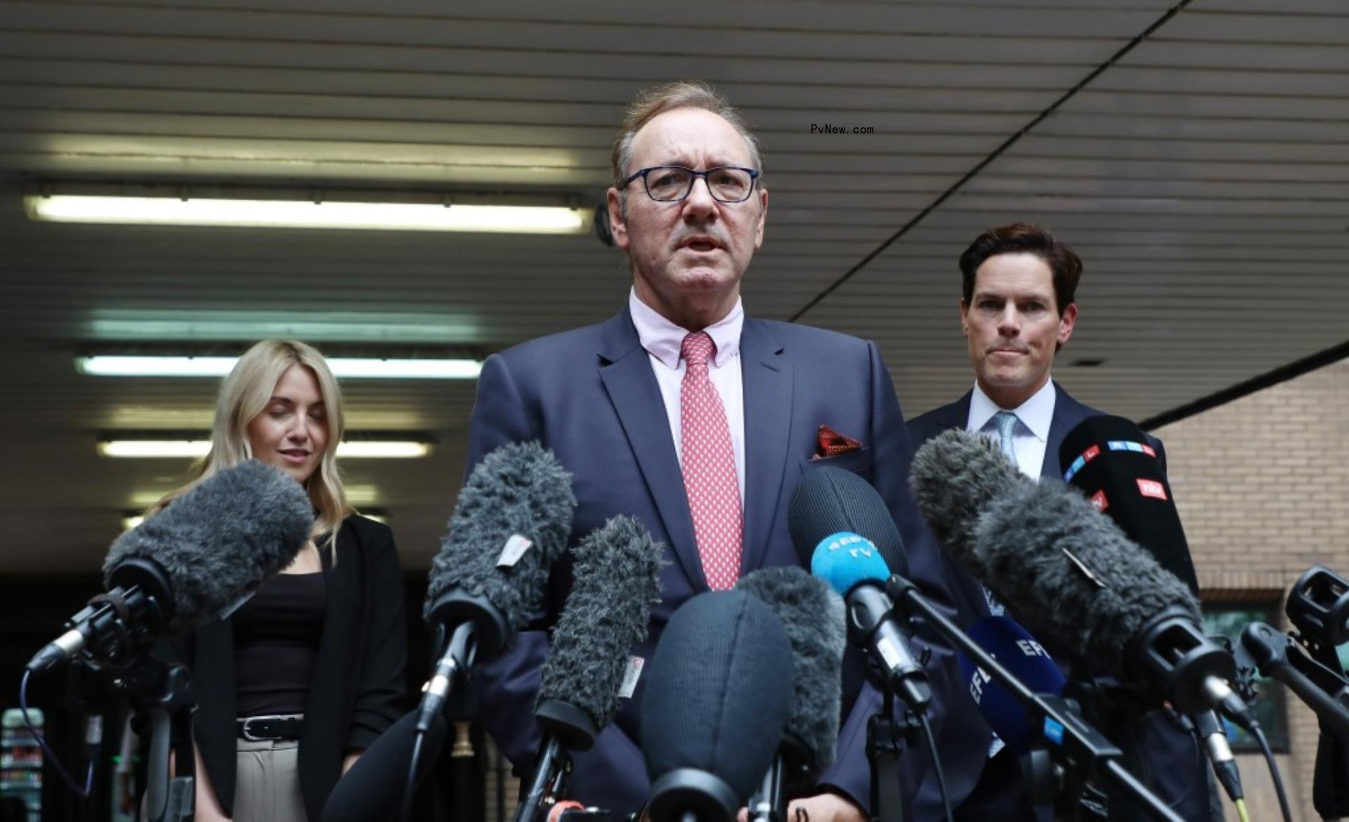 Kevin Spacey in front of several microphones