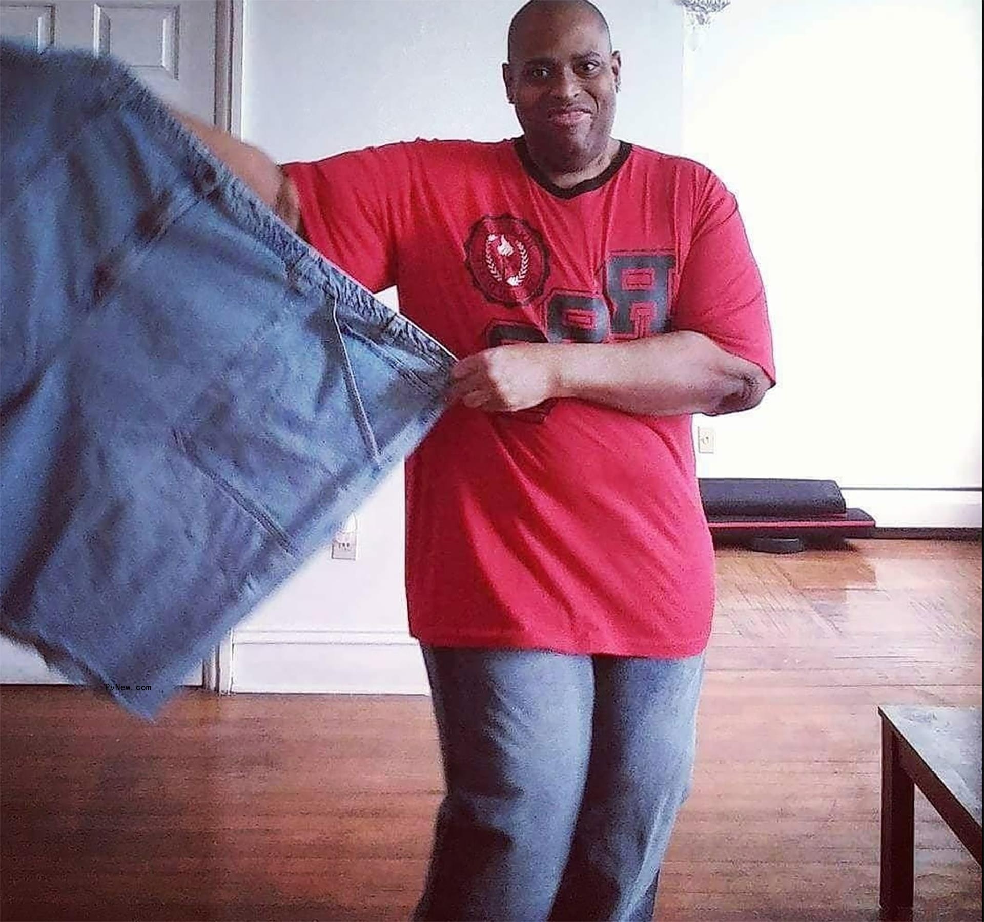 Larry Myers Jr. holding a pair of Jeans.