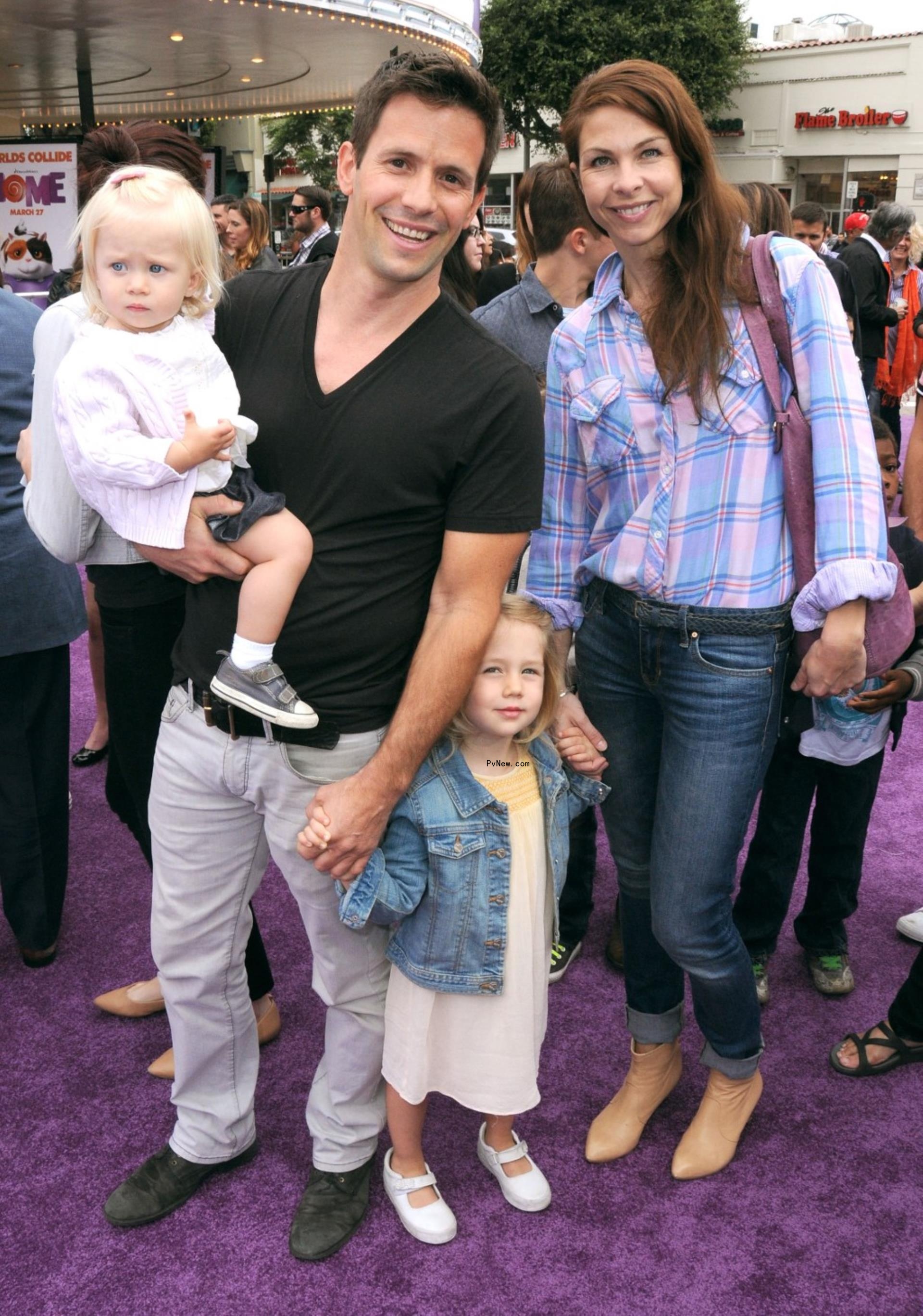 Christian Oliver and Jessica Klepser with their daughters on a red carpet.