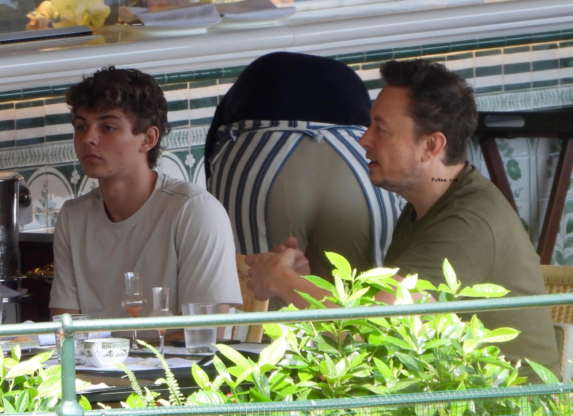 Elon Musk eating with his son at a restaurant.