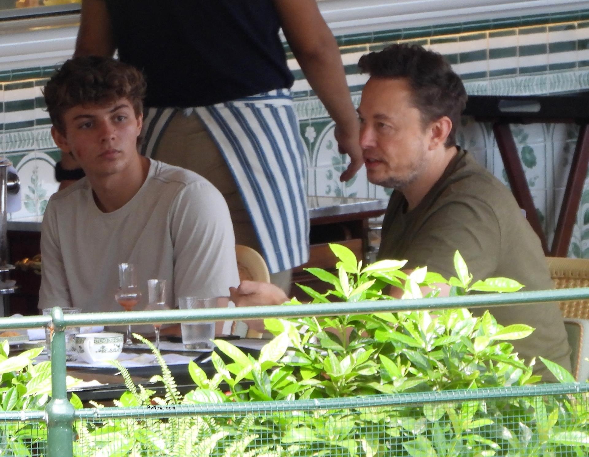 Elon Musk eating with his son at a restaurant.