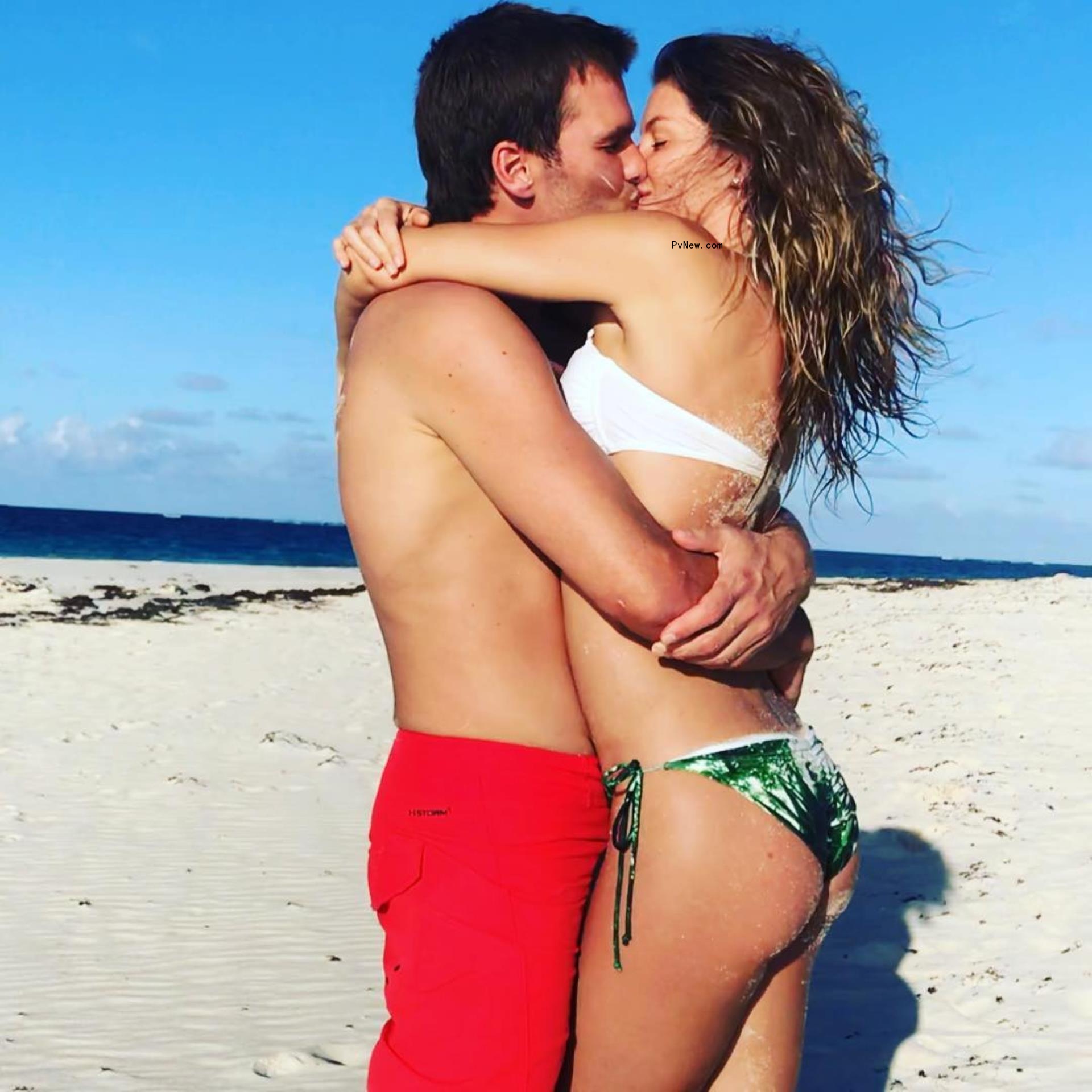 Tom Brady and Gisele Bündhen kissing at the beach.