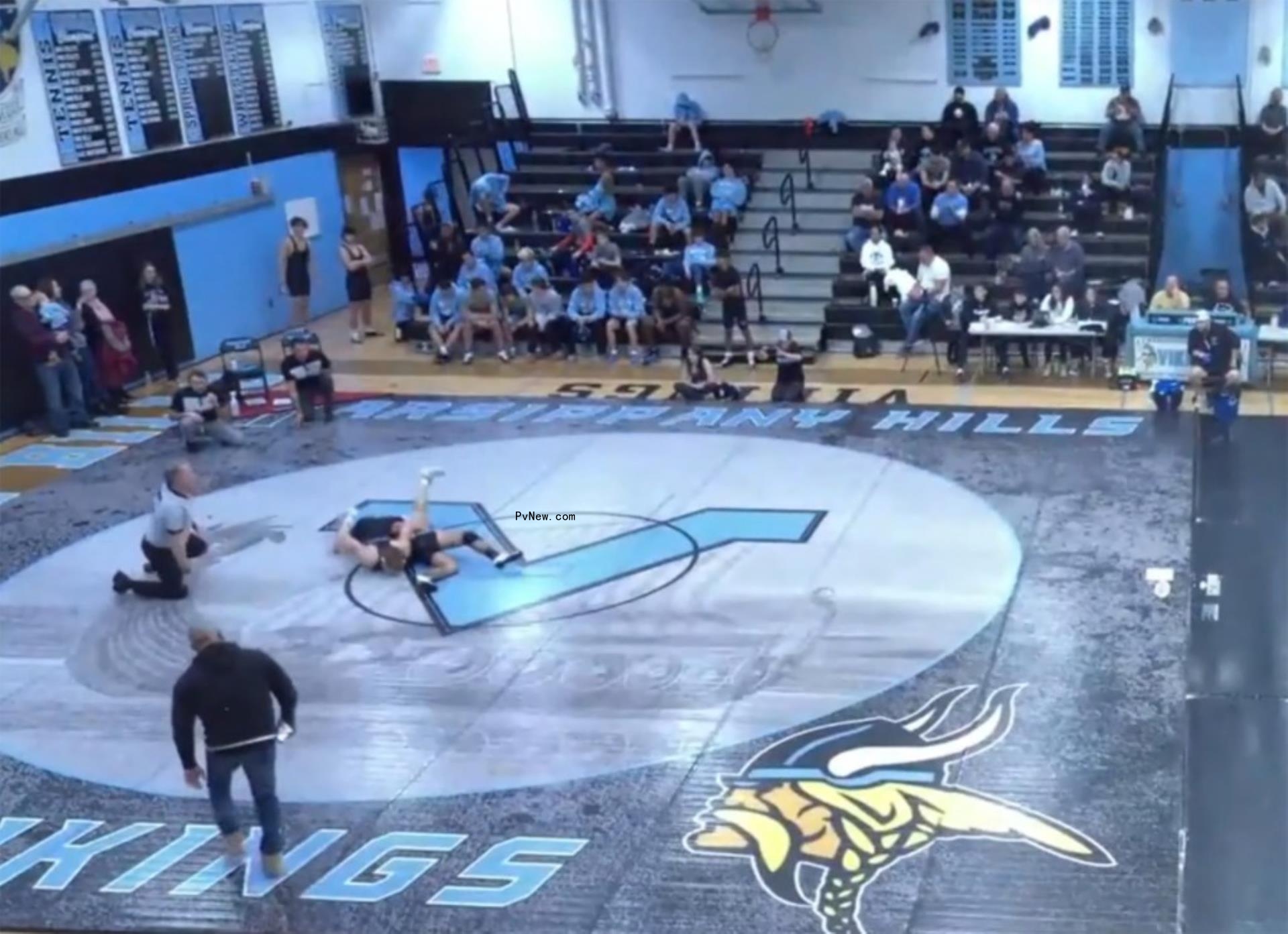joe gorga walking towards a ref as a wrestling match is going on