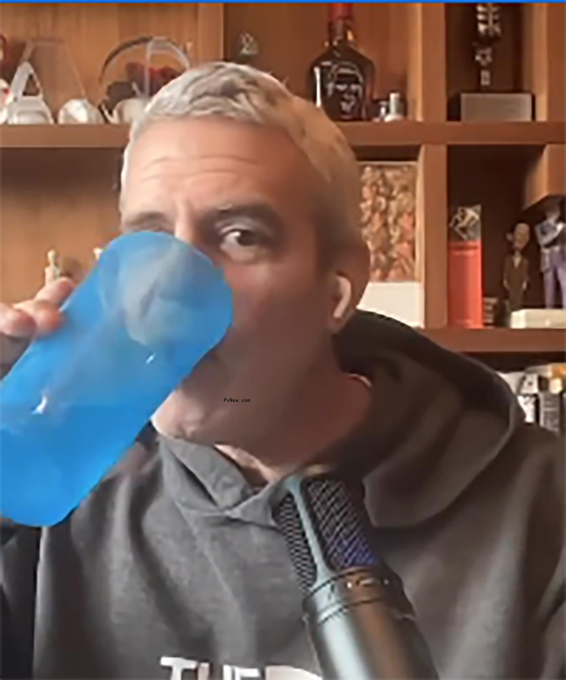 Andy Cohen drinking from a water glass.