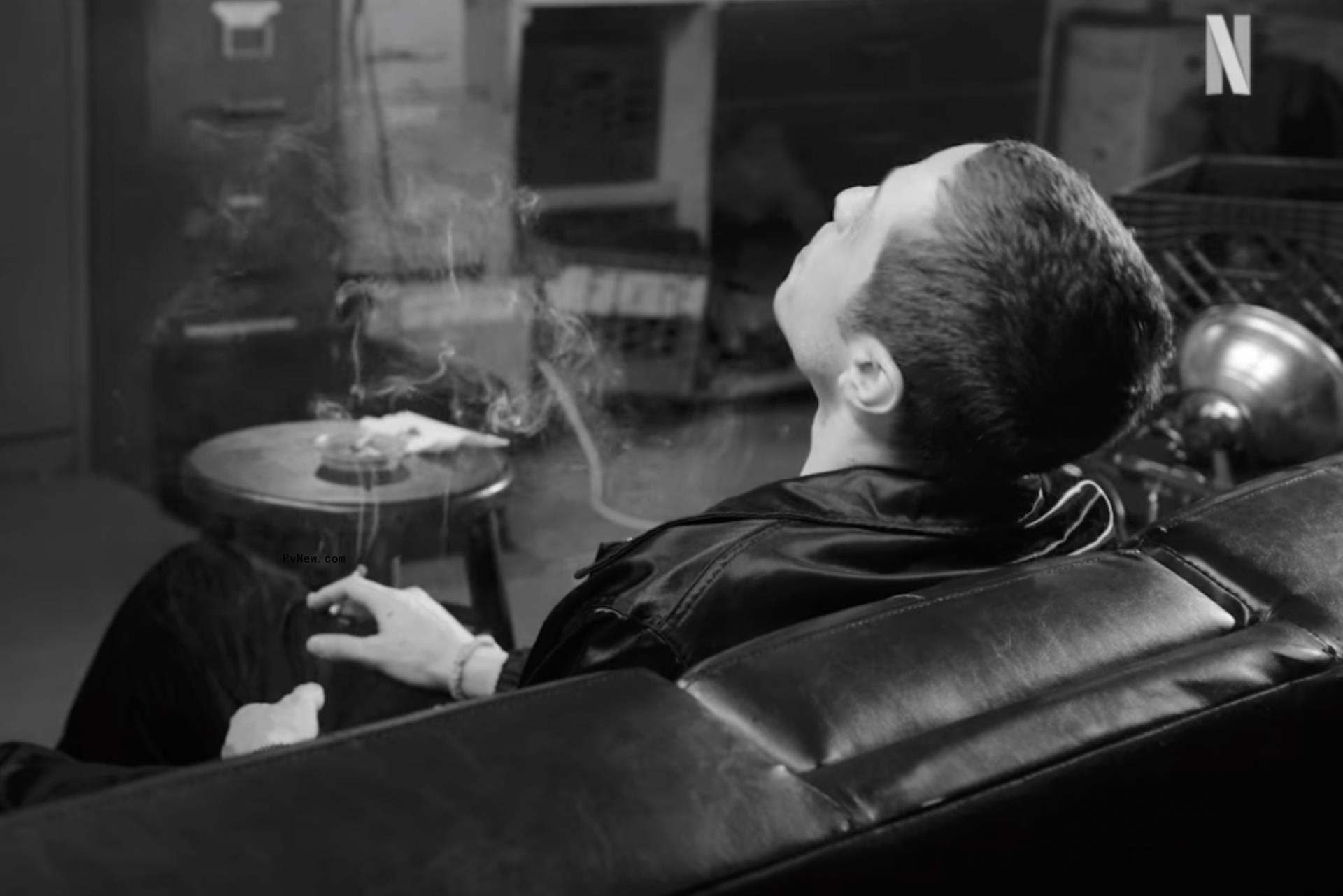 Pete Davidson smoking while sitting on a couch.