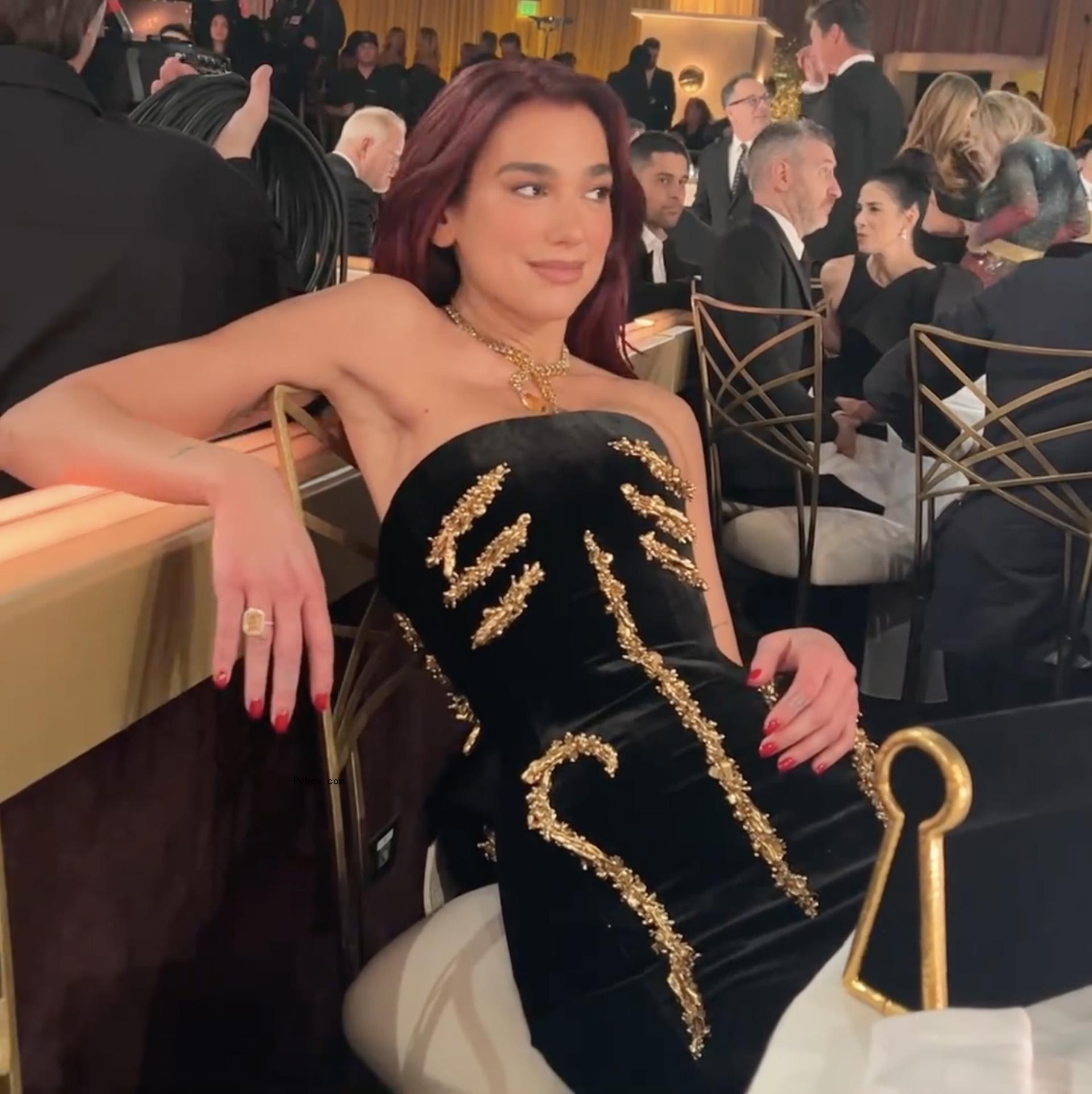 Dua Lipa shares video of herself struggling to sit in elaborate Golden Globes dress.