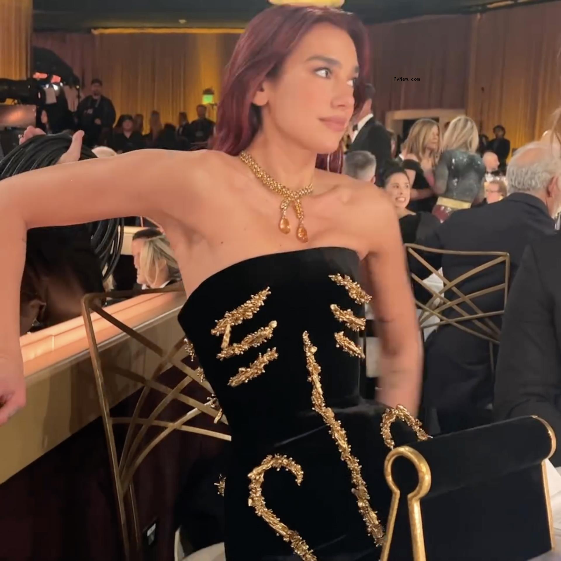 Dua Lipa shares video of herself struggling to sit in elaborate Golden Globes dress.
