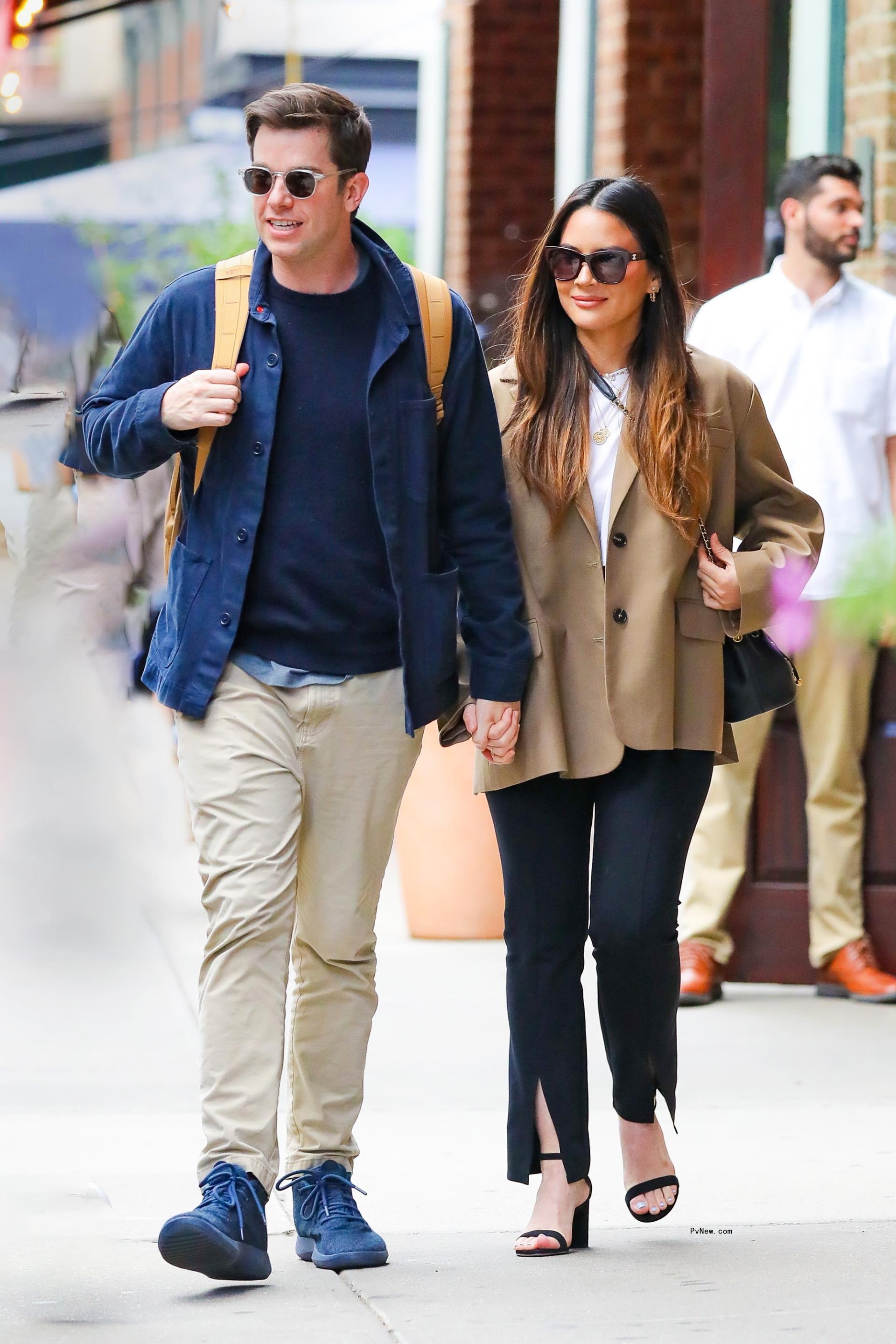 John Mulaney and Olivia Munn walking together.