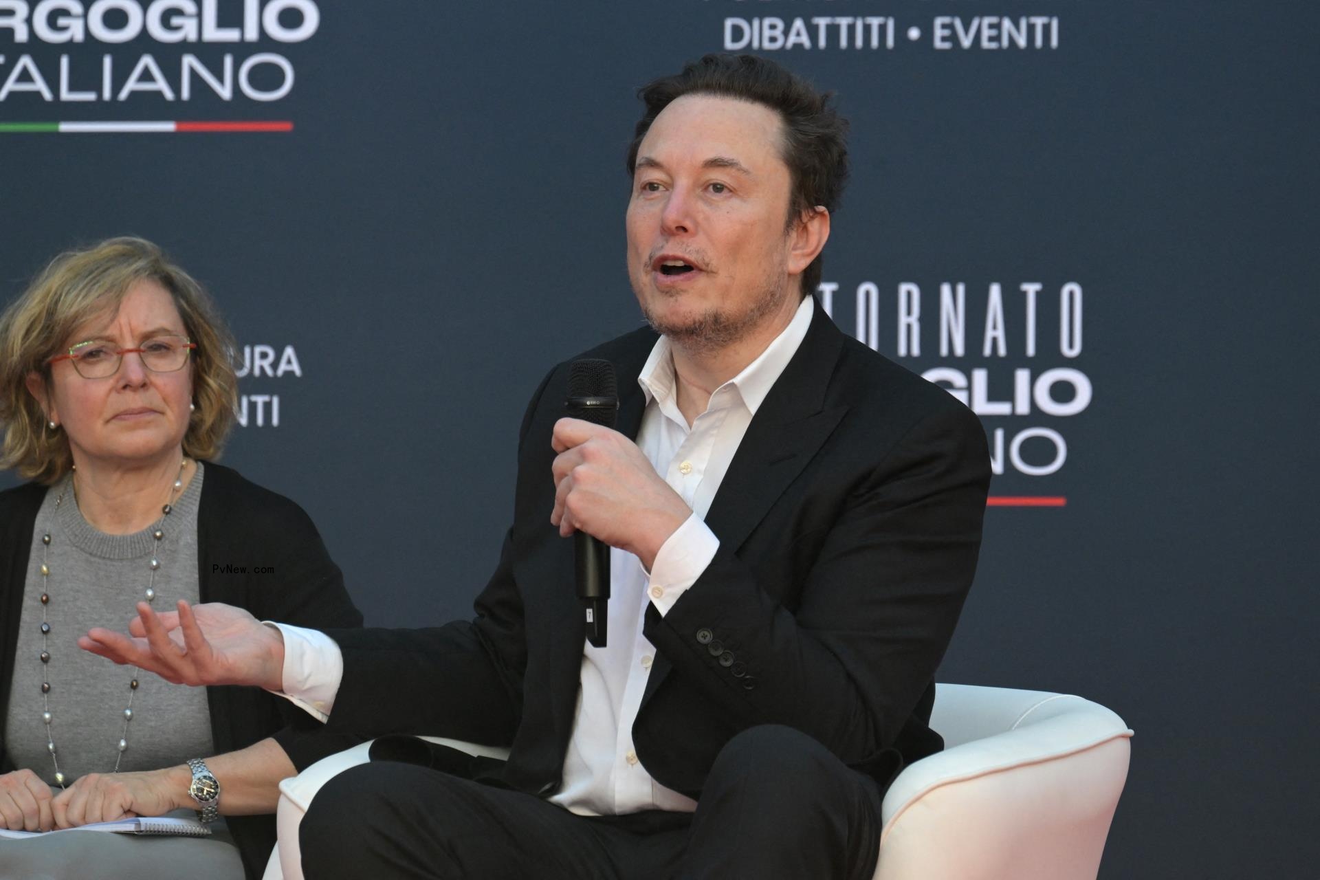 Elon Musk speaking into a mic.