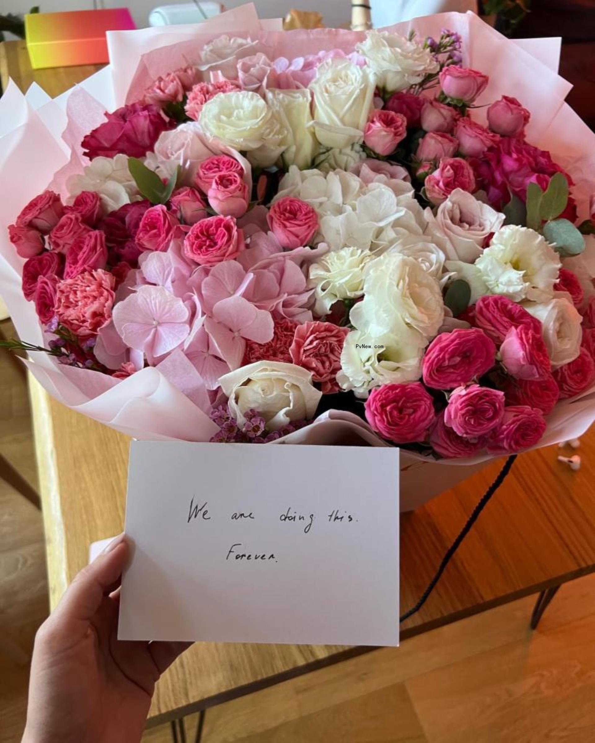 a huge bouquet of flowers with a card that reads