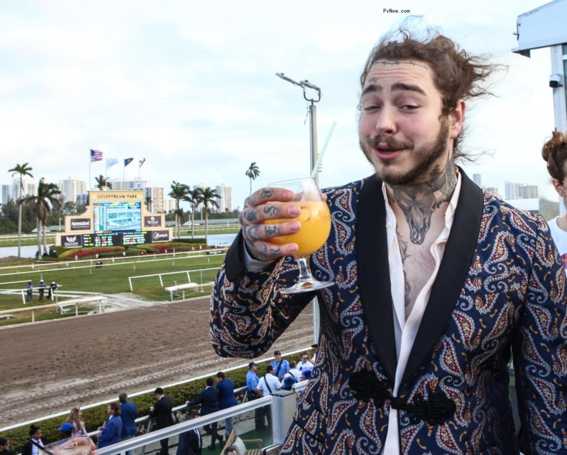Post Malone holding a drink.