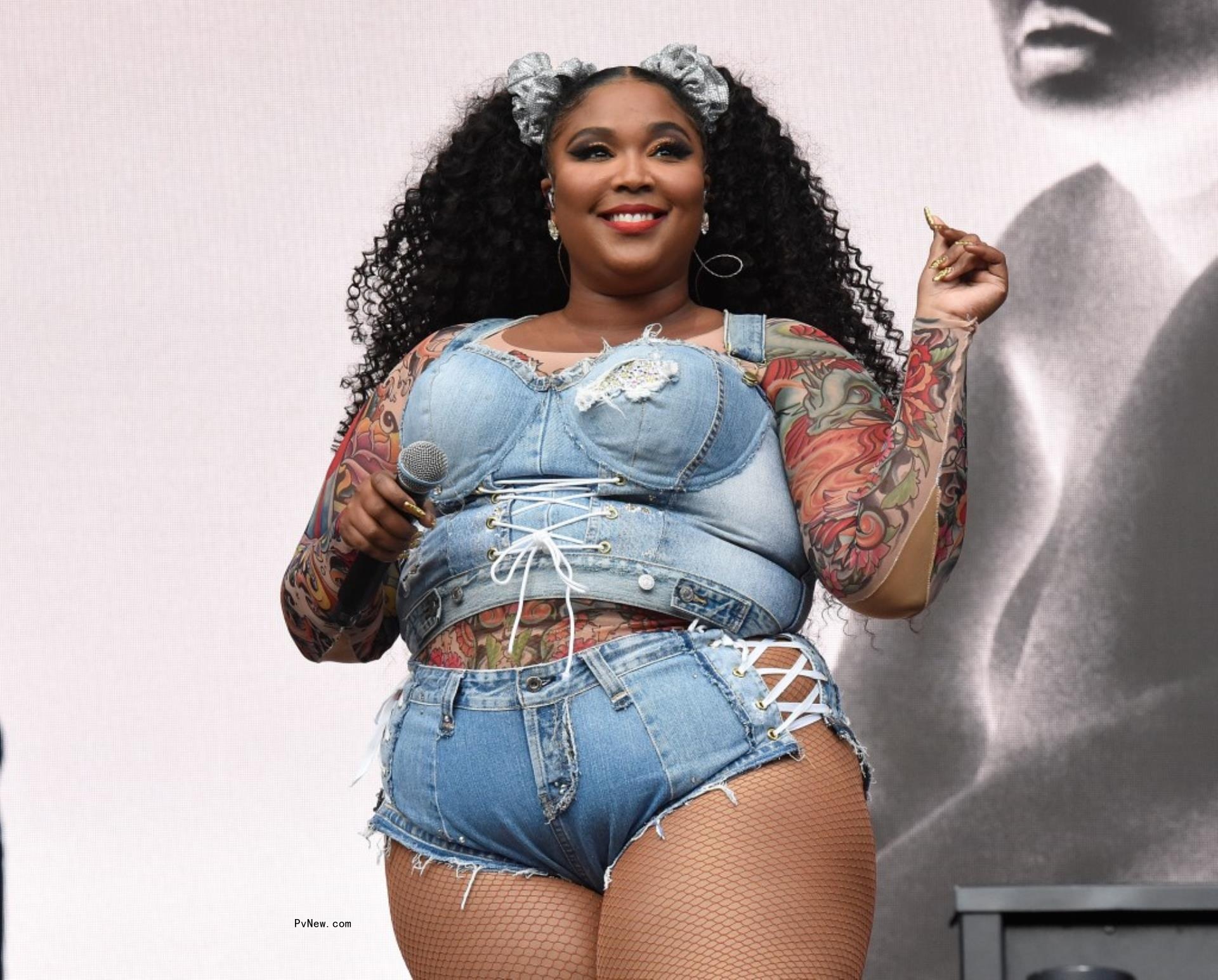 Lizzo o<i></i>nstage in a denim outfit.