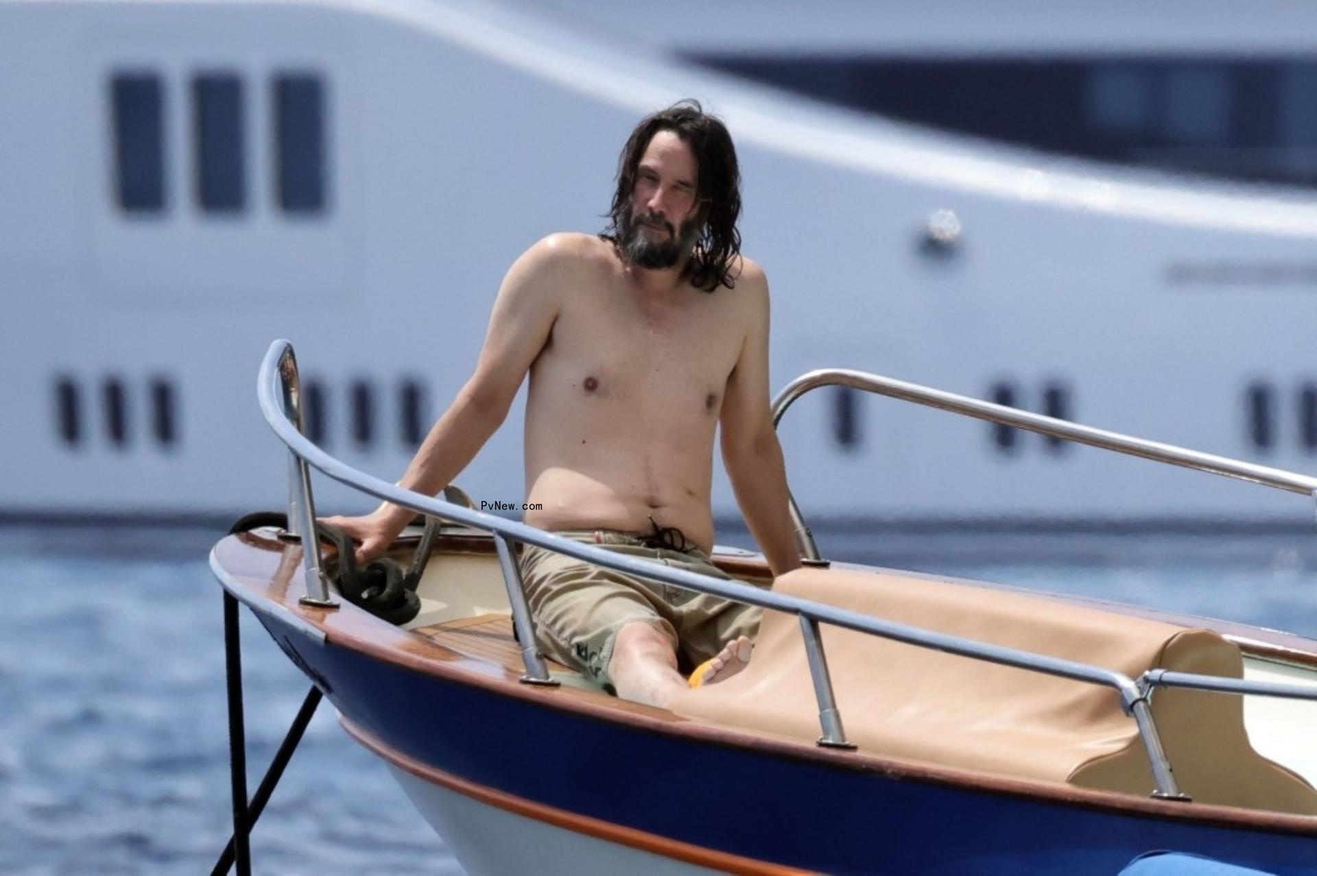 shirtless keanu reeves on a boat in italy