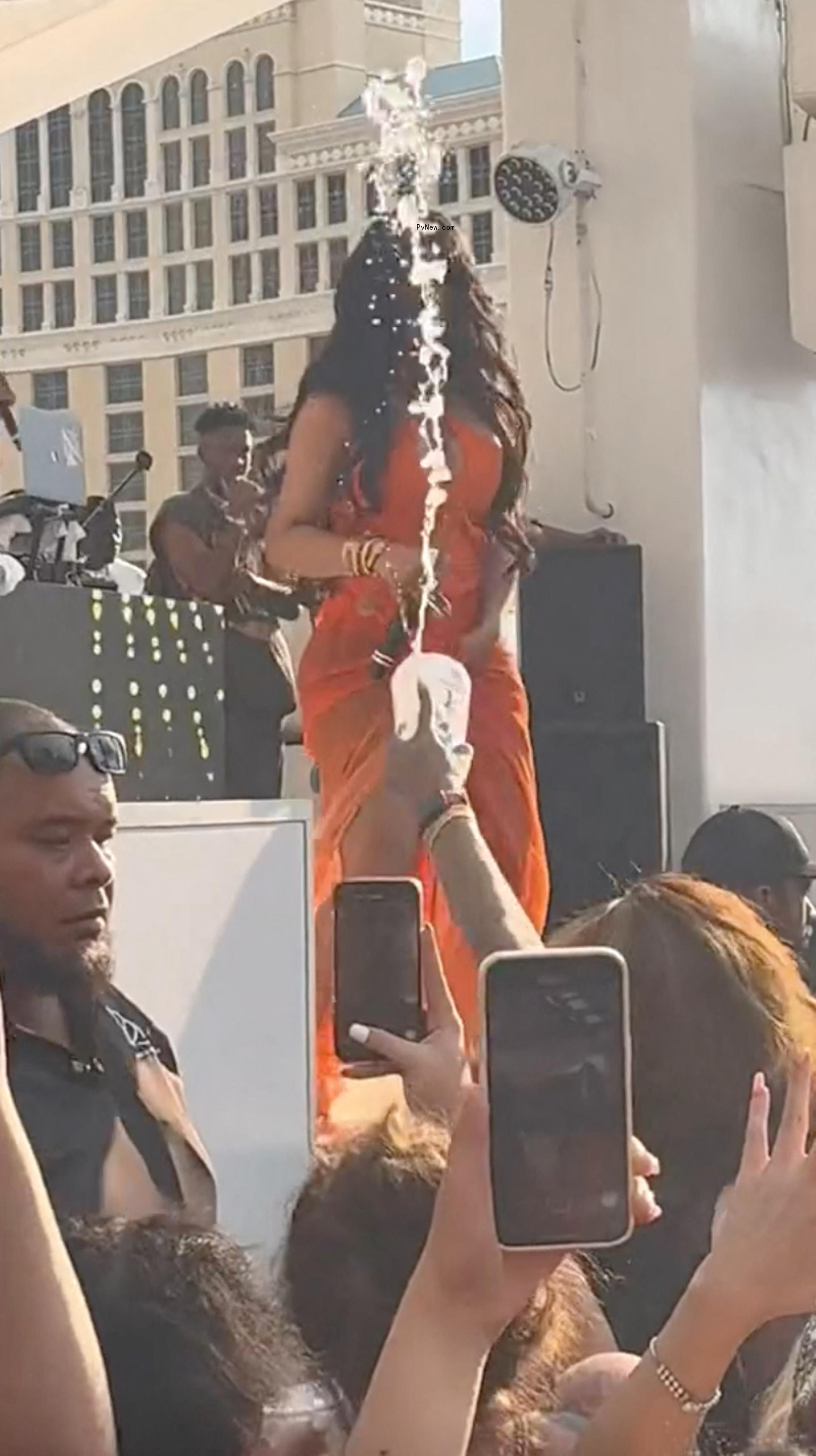 A fan throwing water on Cardi B.
