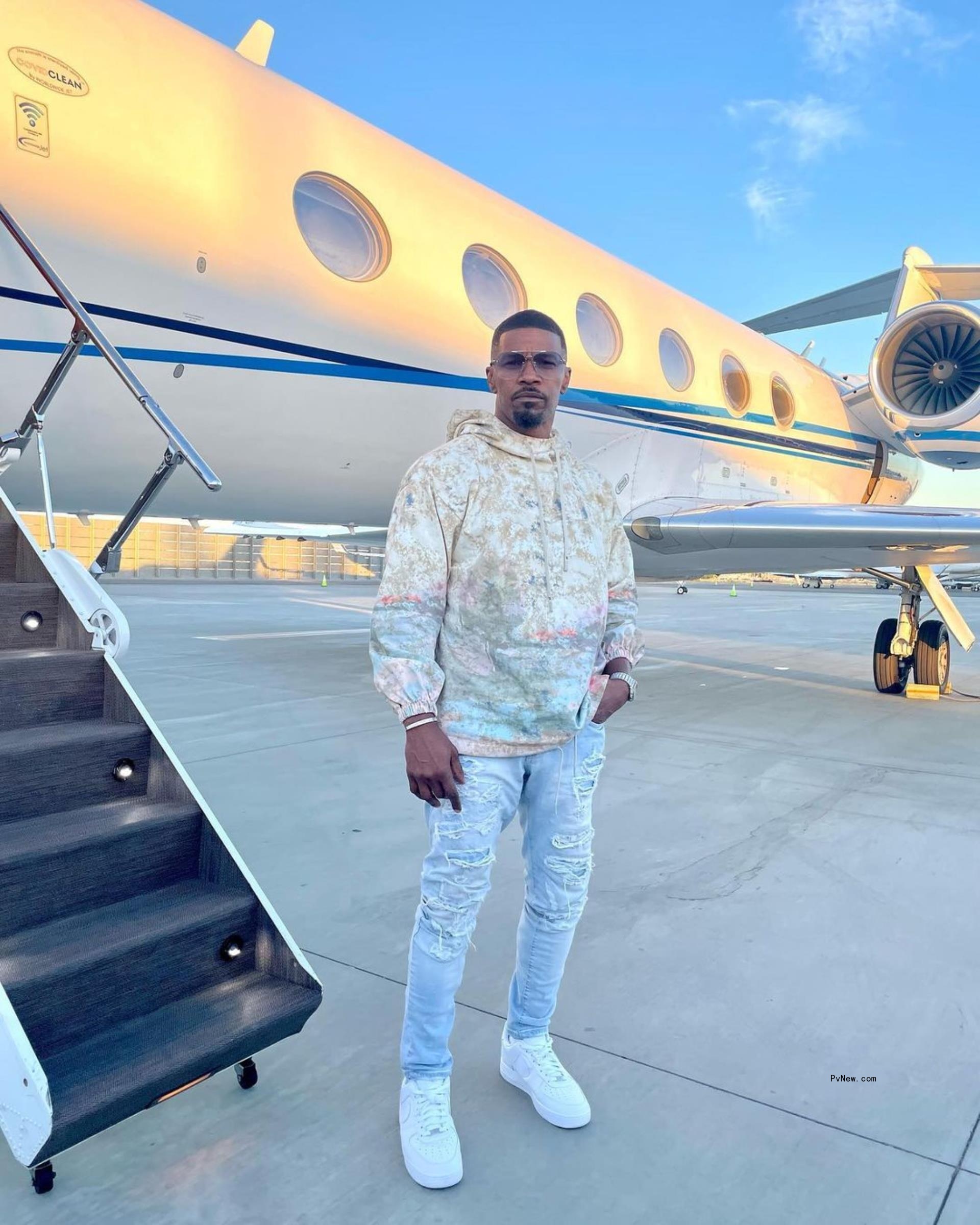 Jamie Foxx in front of a plane.