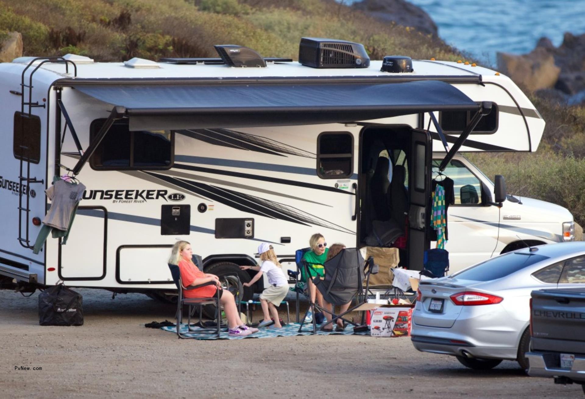 Tori Spelling and her kids in front of her RV at the campsite.